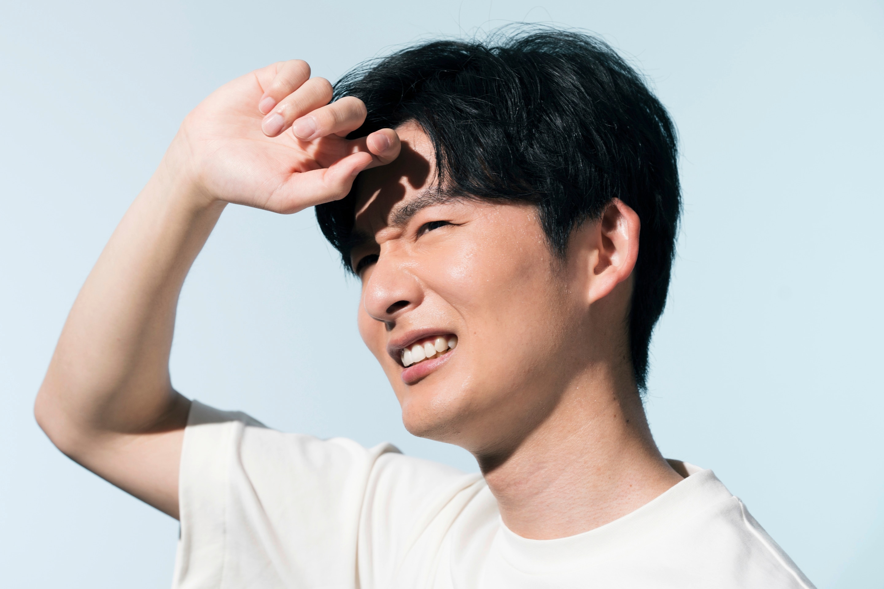 ada pria Asia sedang berkeringat karena kepanasan.