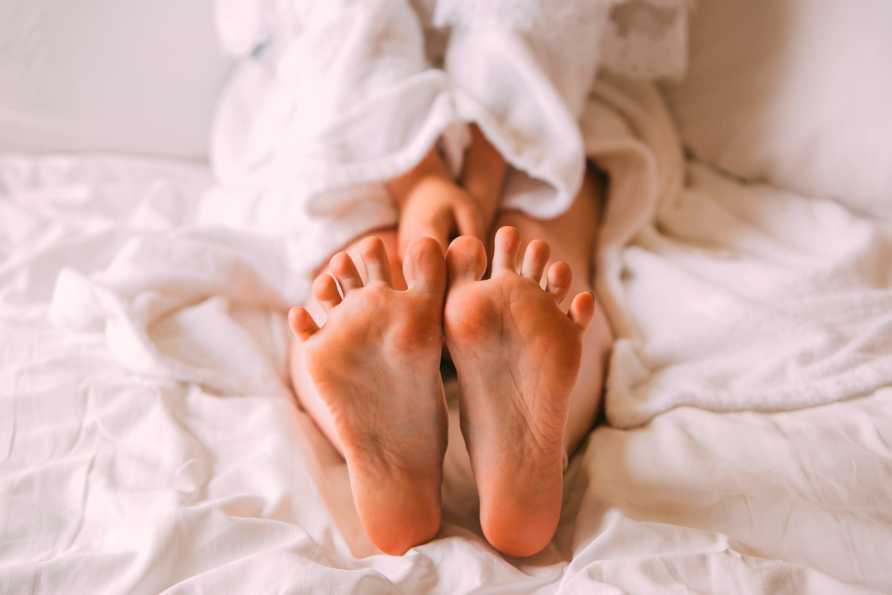 ada telapak kaki di atas tempat tidur yang menggambarkan kondisi telapak kaki berkeringat dan lembap.