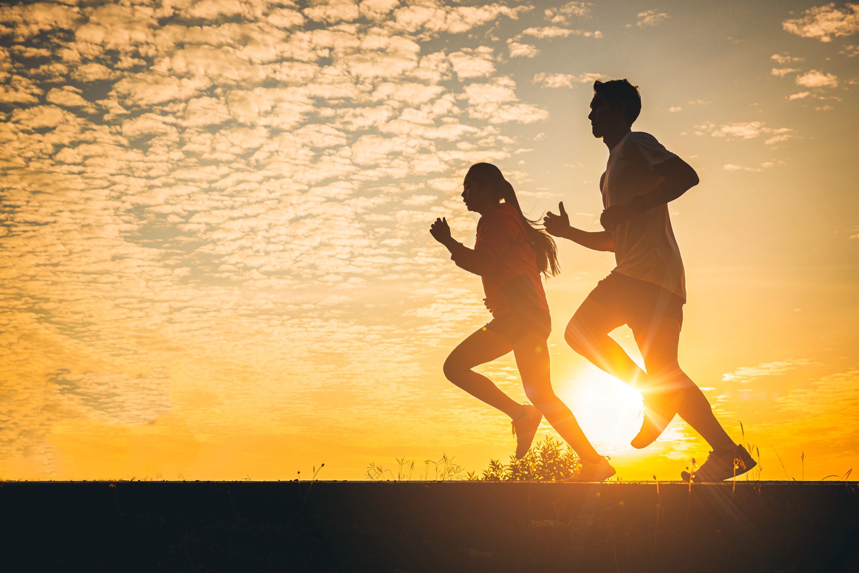 ada pasangan pria dan wanita yang sedang berolahraga di sore hari.