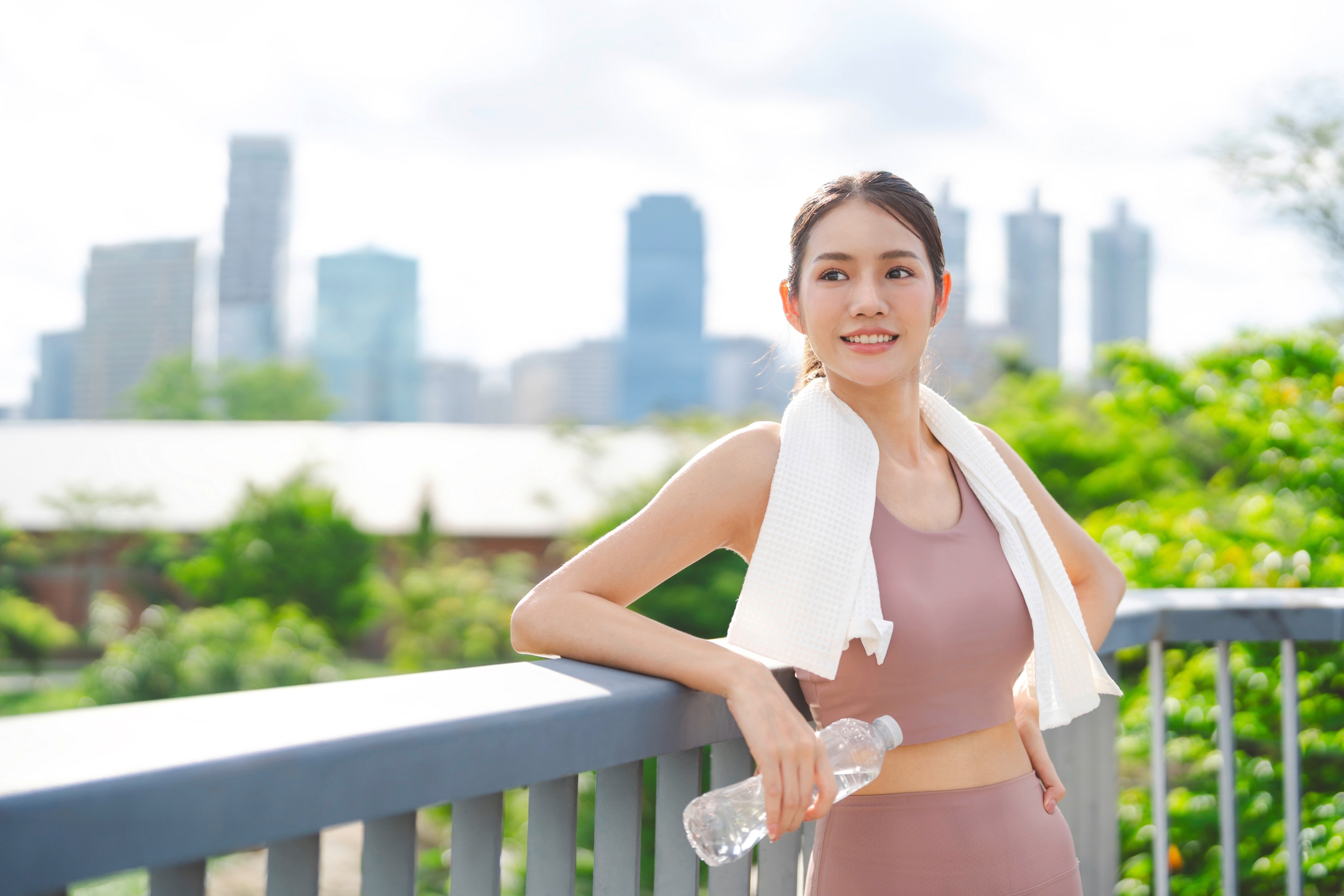 ada wanita asia yang sedang beristirahat setelah berolahraga di pagi hari.