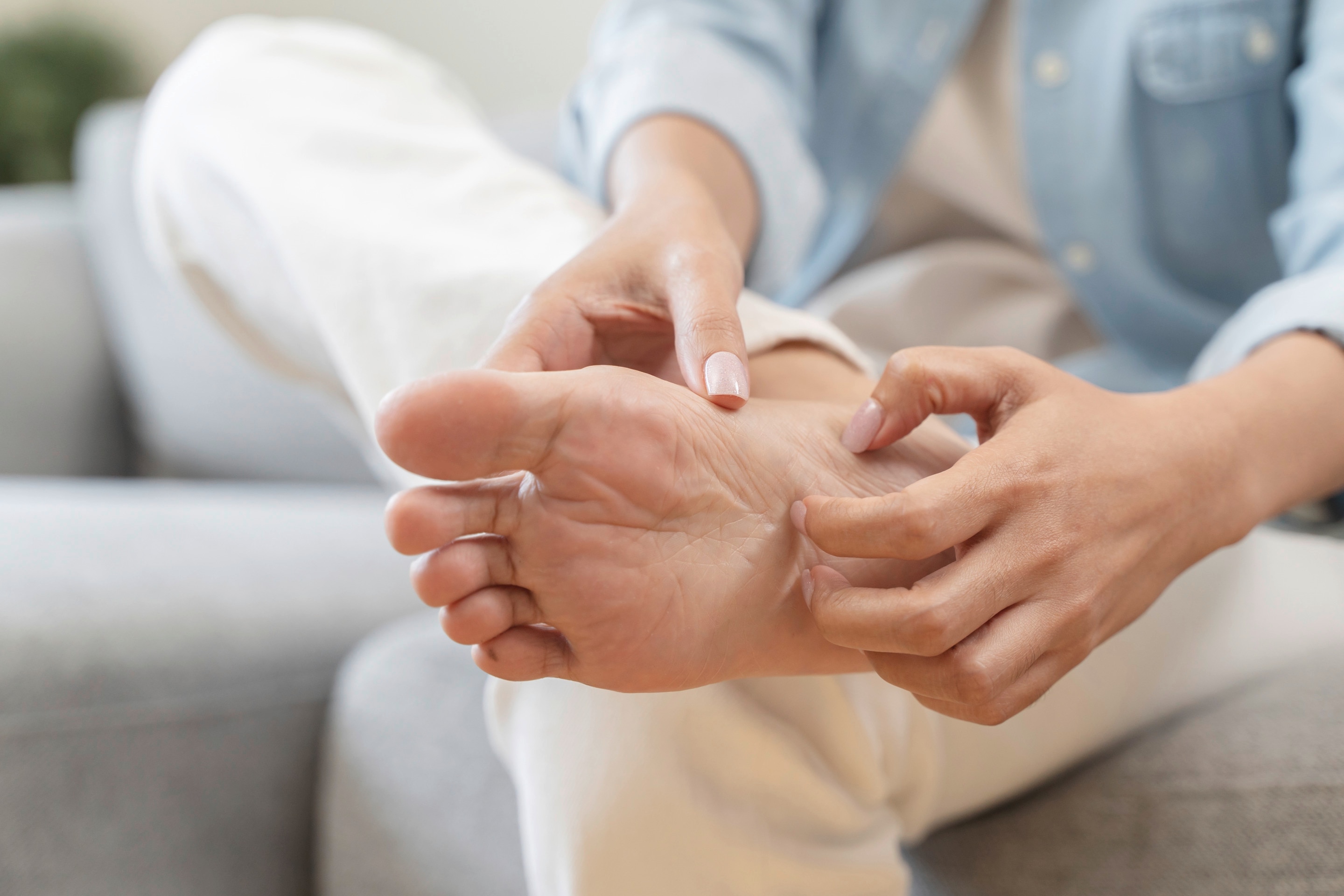 Seperti yang terlihat pada foto, ada wanita Asia sedang menggaruk kaki yang kering dan mengelupas