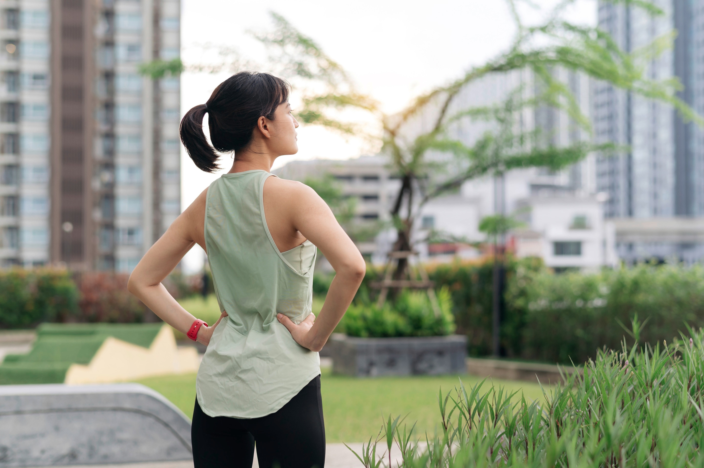 Woman looking ahead, her back to the camera, wearing sports attire.