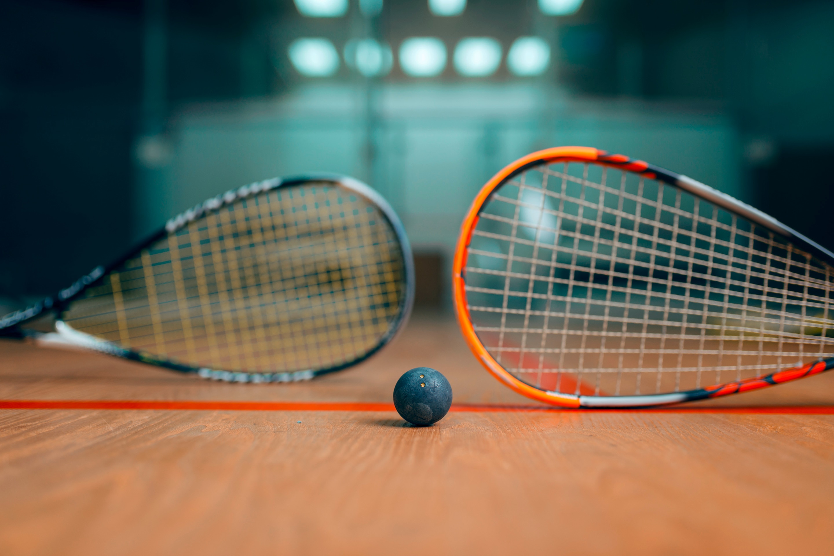 ada sepasang raket dan bola squash.