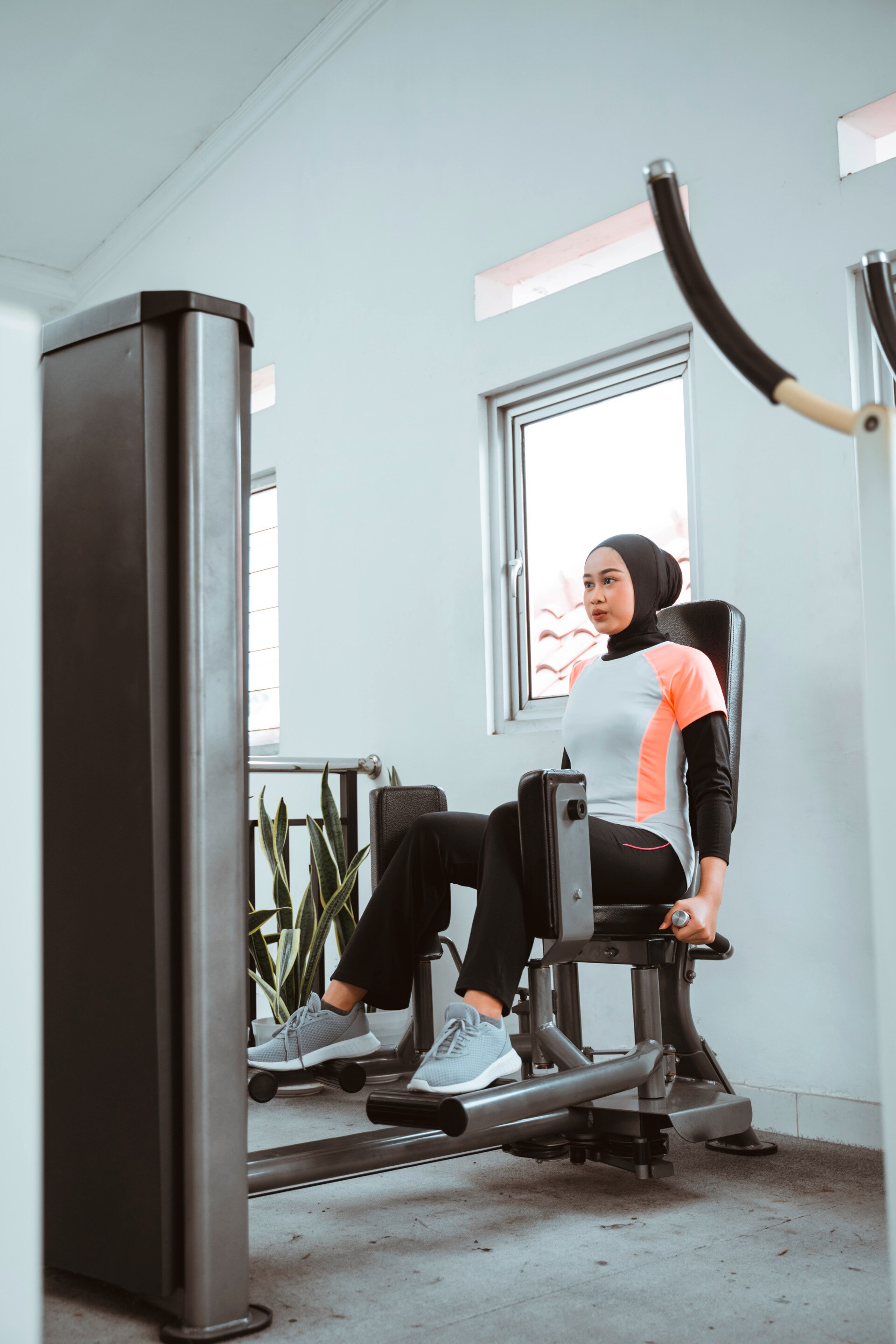 wanita berhijab sedang berolahraga di gym.