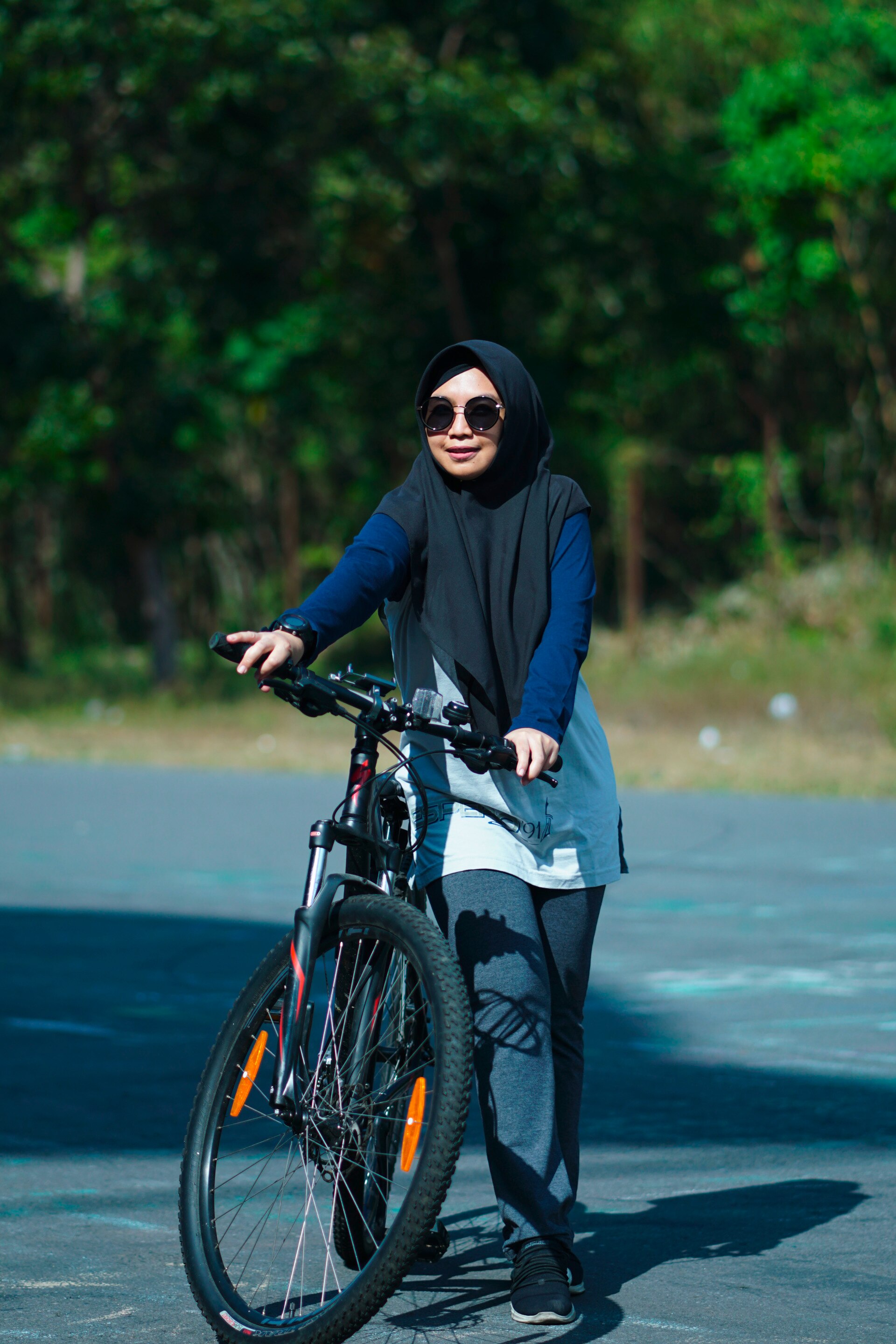 wanita berhijab sedang bersepeda.