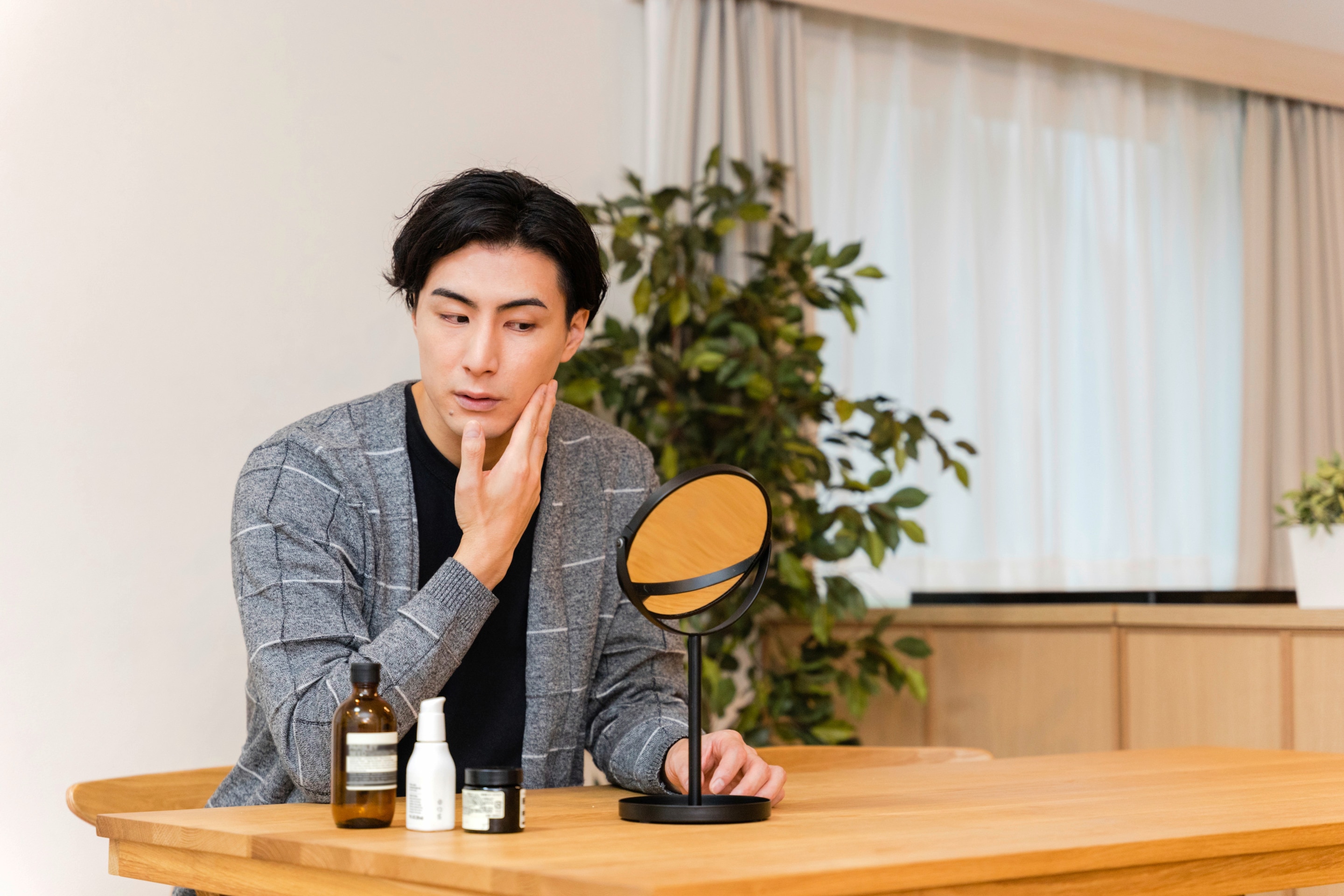 Man checking his skin in front of a small mirror.