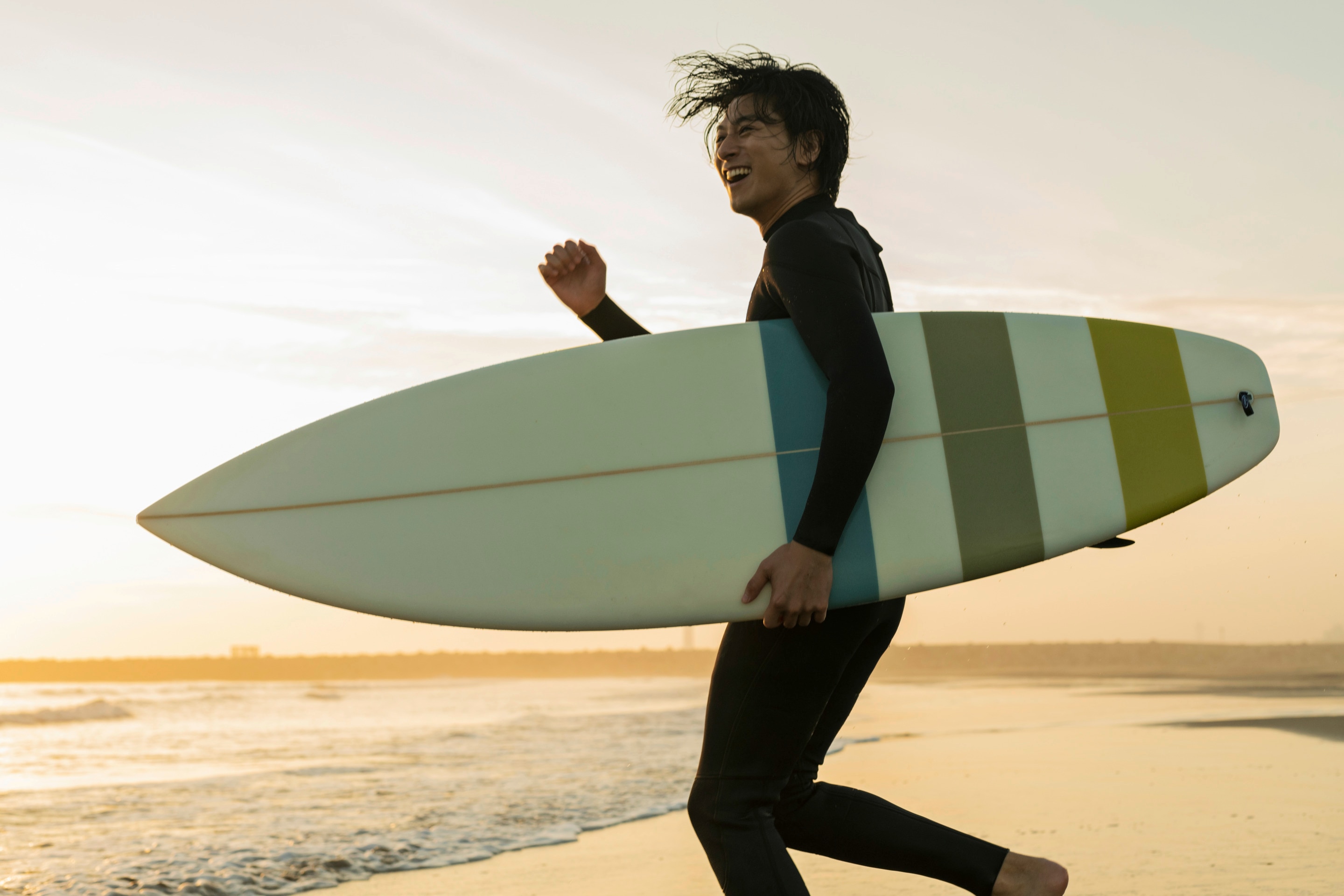 Man with surfboard by the beach.