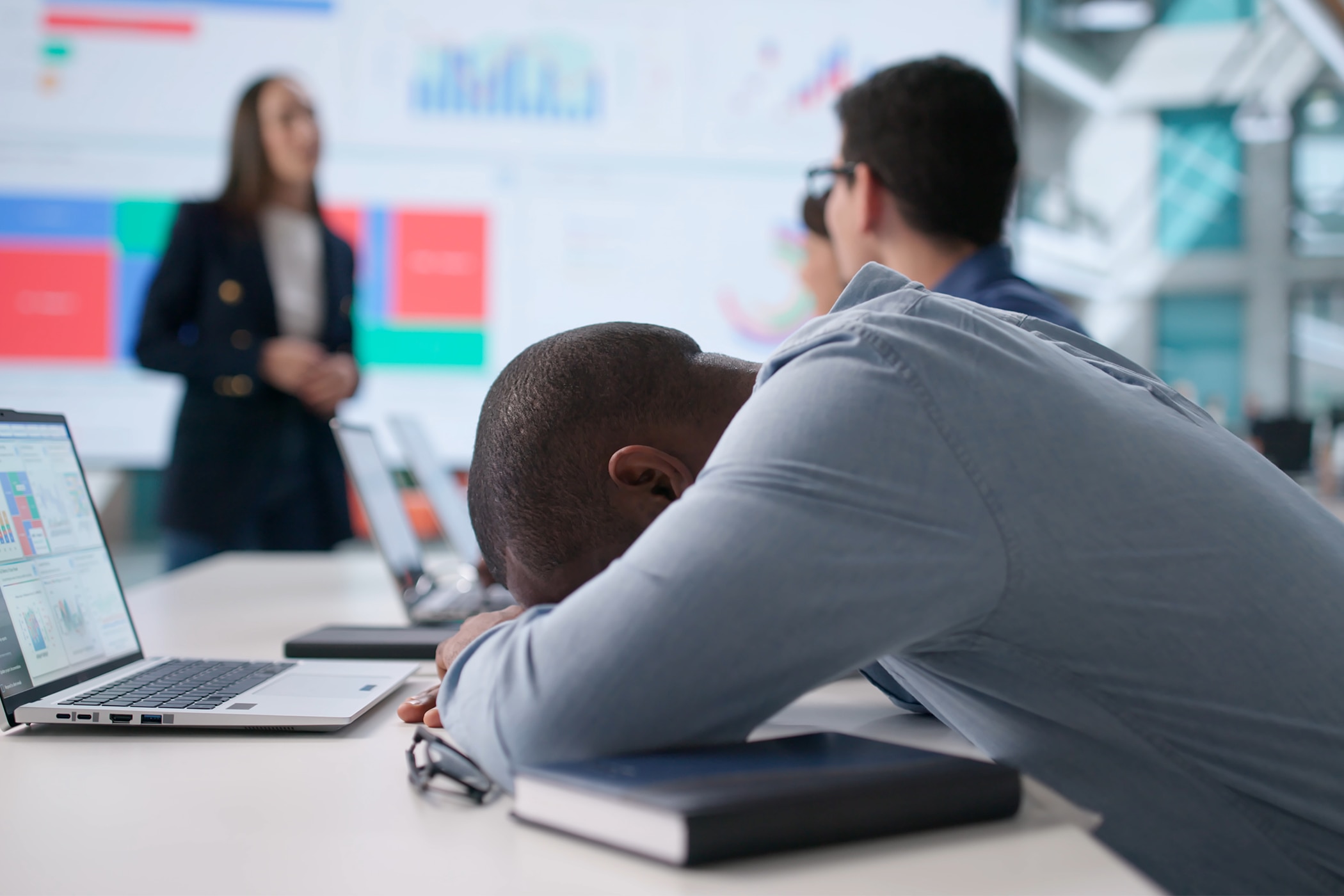 Man lying on his arms during a work presentation and needing find tips to help him reduce stress and anxiety. 