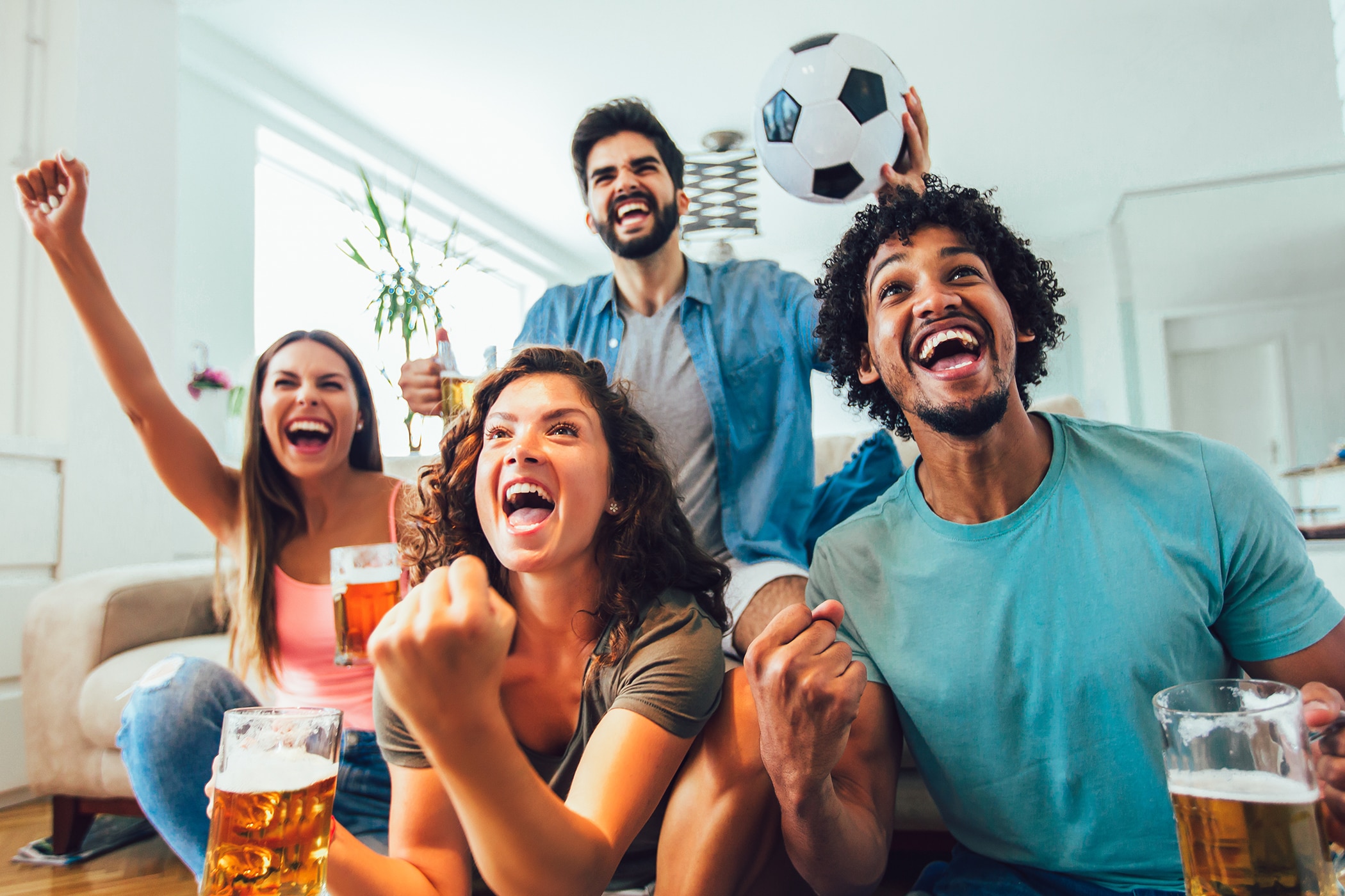 Fans watching a soccer game at home while wearing the best antiperspirant for hot weather