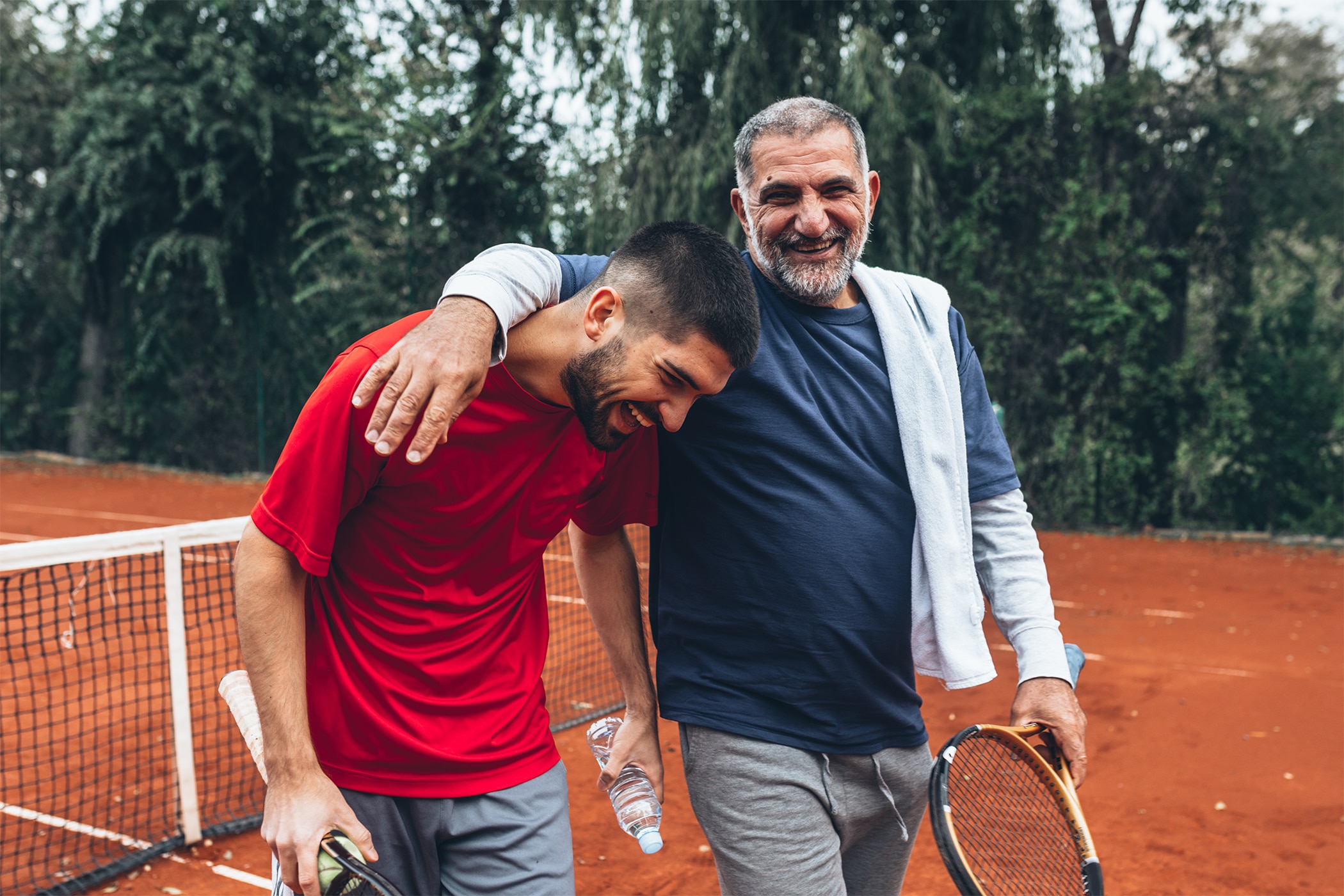 Father and son playing tennis while wearing clinical strength antiperspirant