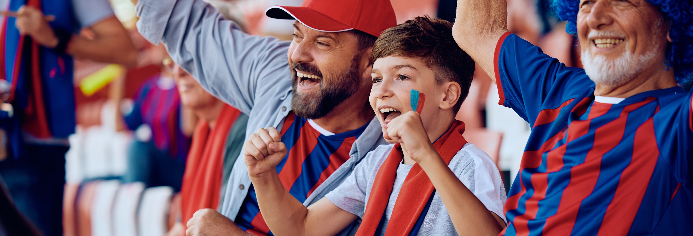 Happy father, son and grandson at a soccer match wearing soccer summer gear 