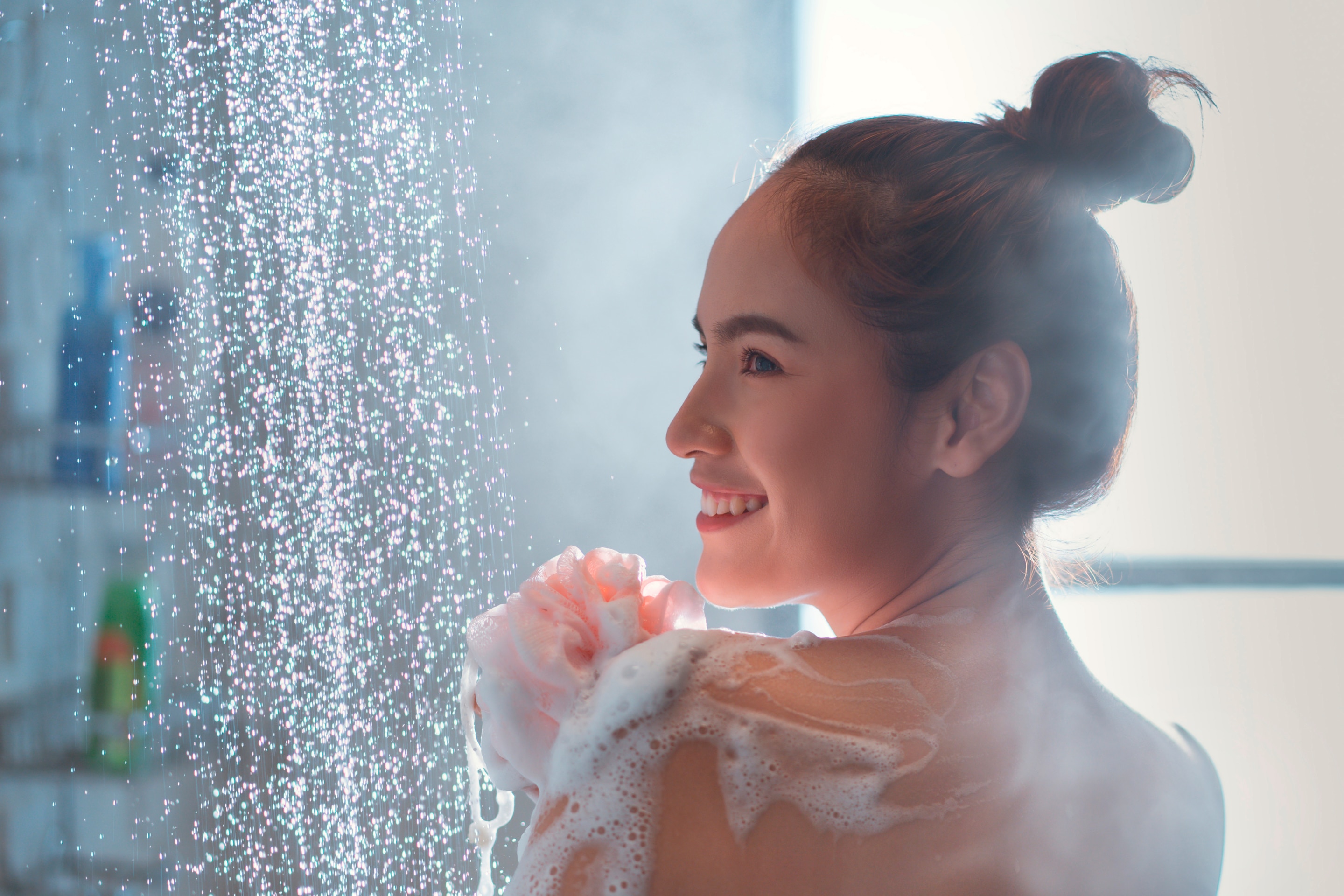 Wanita Asia sedang membersihkan tubuh pakai sabun saat mandi