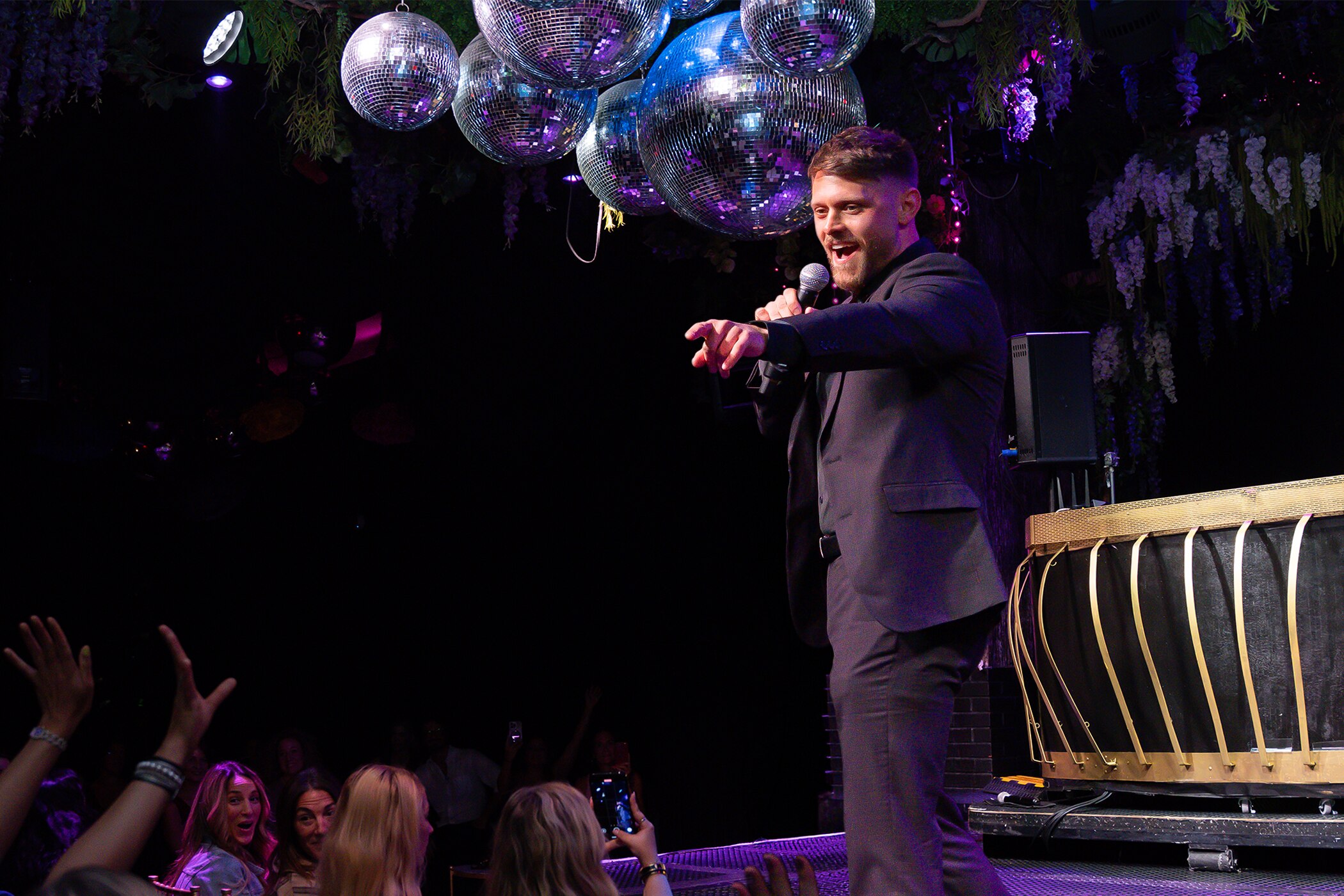 Author and dating strategist Benny Hart on stage speaking to a room full of people