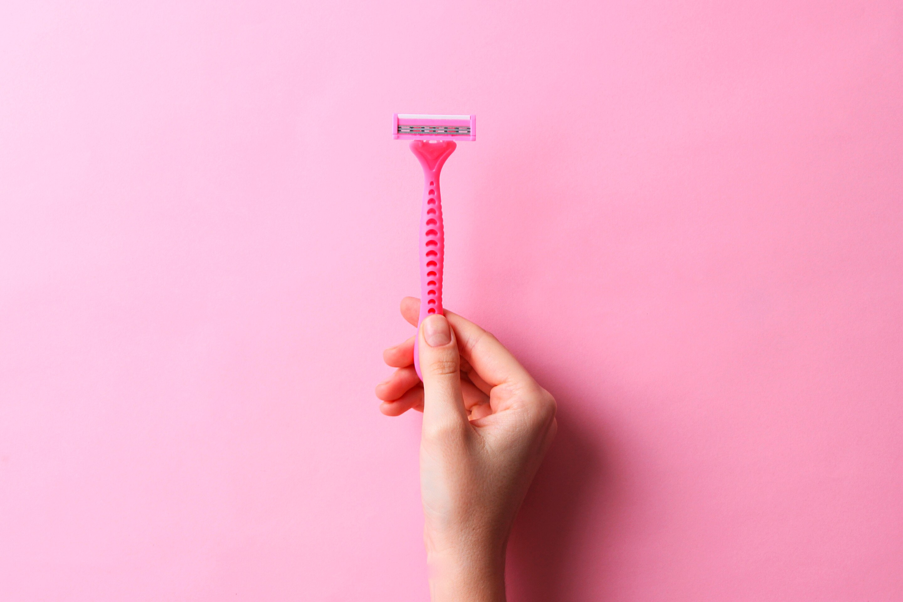  Seperti yang terlihat pada foto, tangan wanita sedang menggenggam razor berwarna pink. 