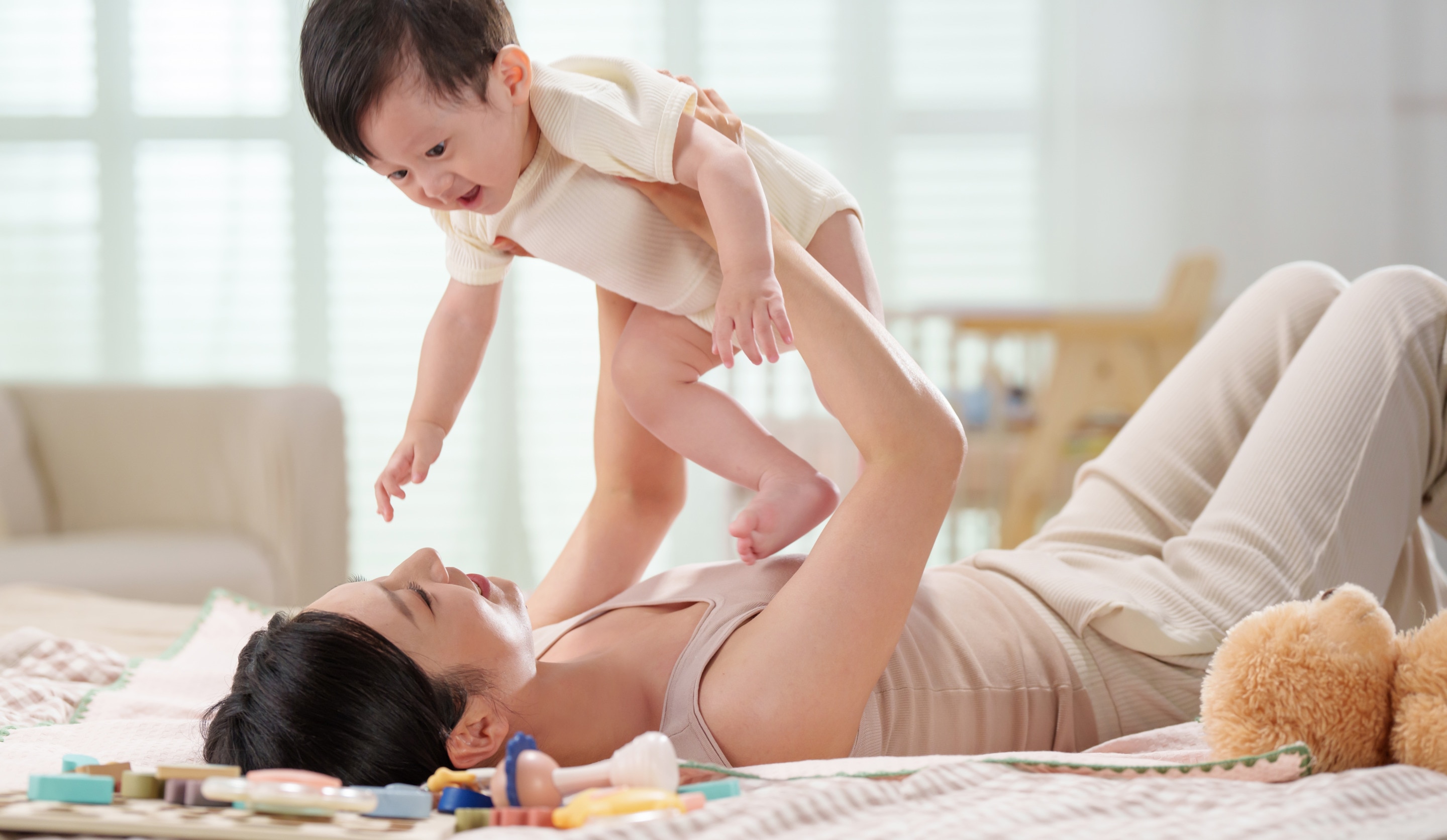 terlihat seorang ibu sedang bermain dengan mengangkat anaknya.