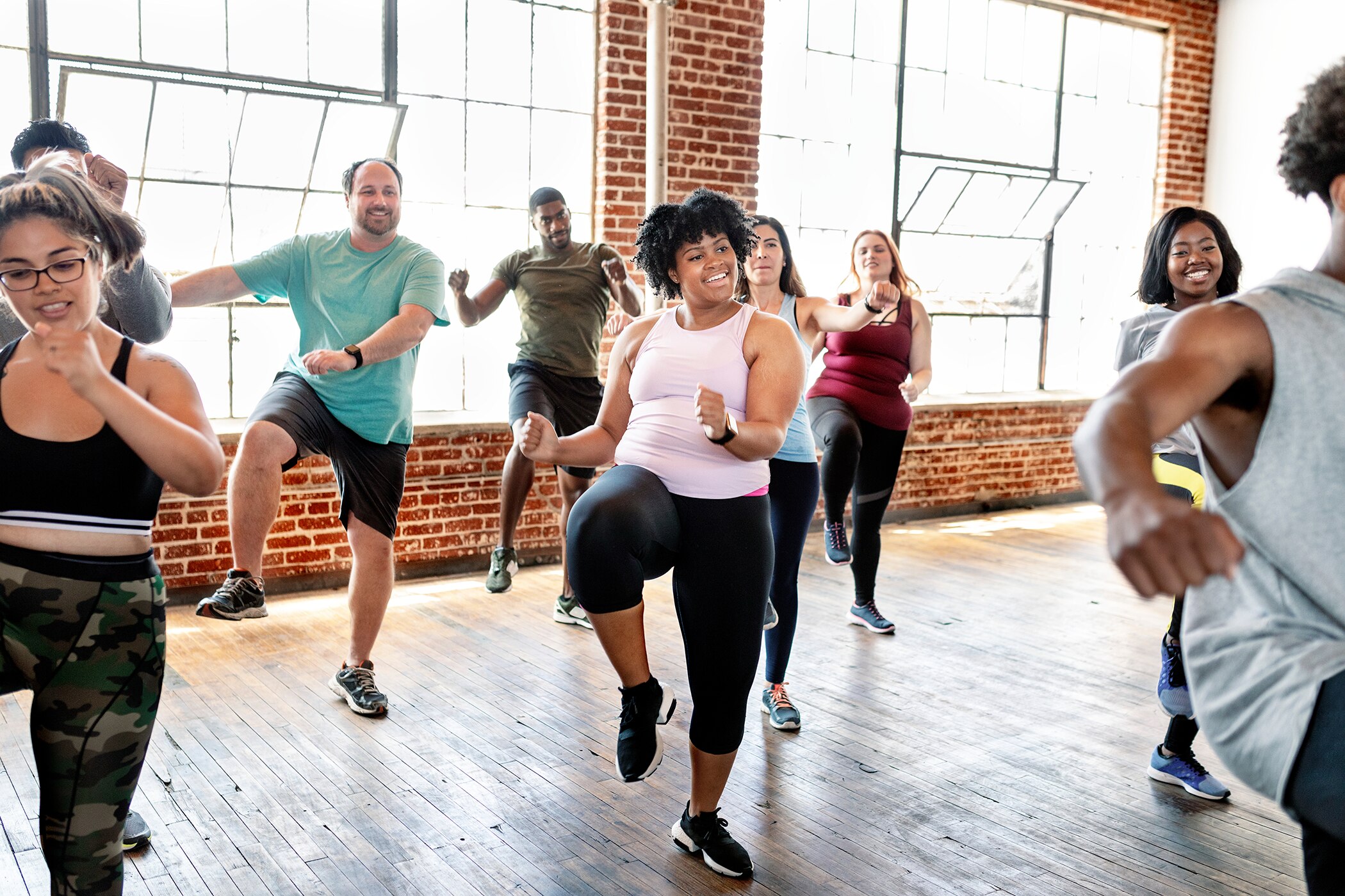 Group of friends exercising together in a workout studio while wearing fresh deodorant