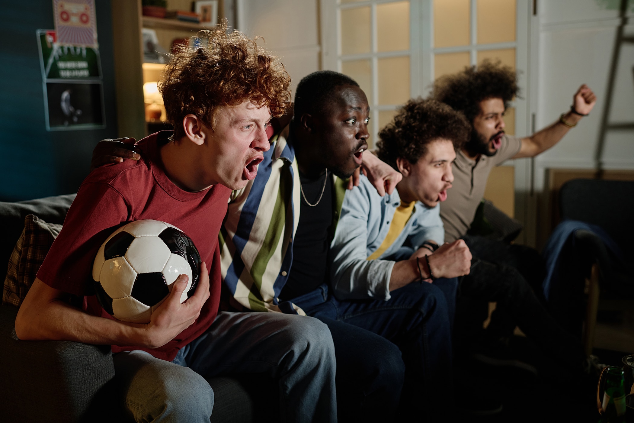 Group of diverse friends watching the soccer world cup together while wearing the best deodorant for sweating 