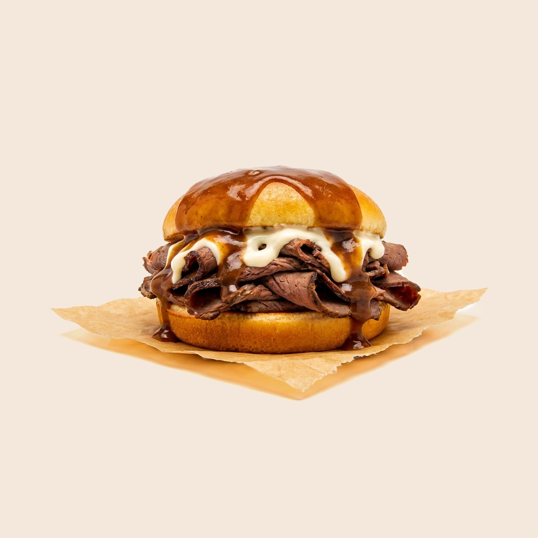 Open-faced hot roast beef sandwich on a bun with mayo, smothered in rich brown gravy. 