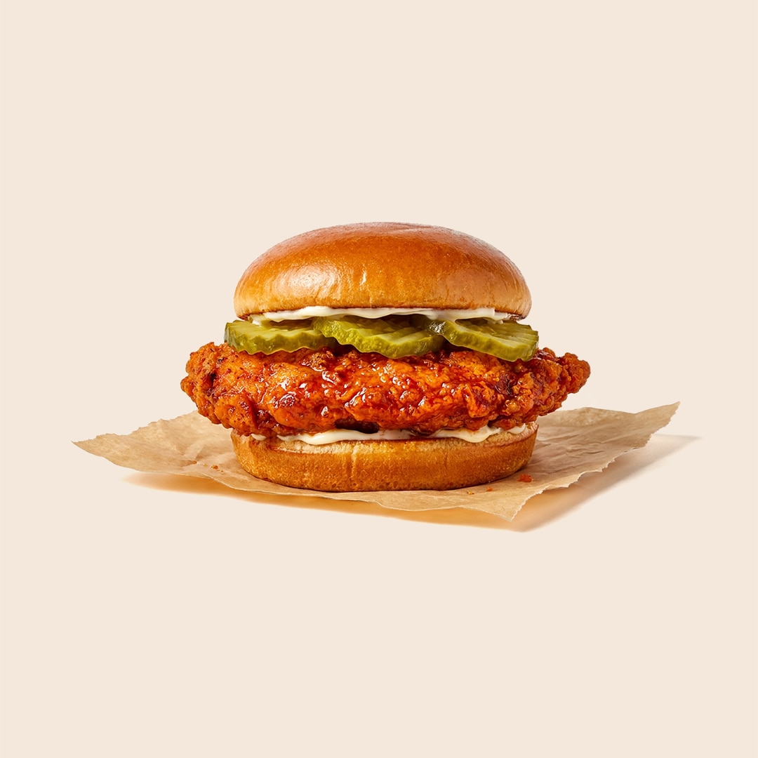 Nashville hot chicken sandwich on a brioche bun with pickles and mayonnaise.
