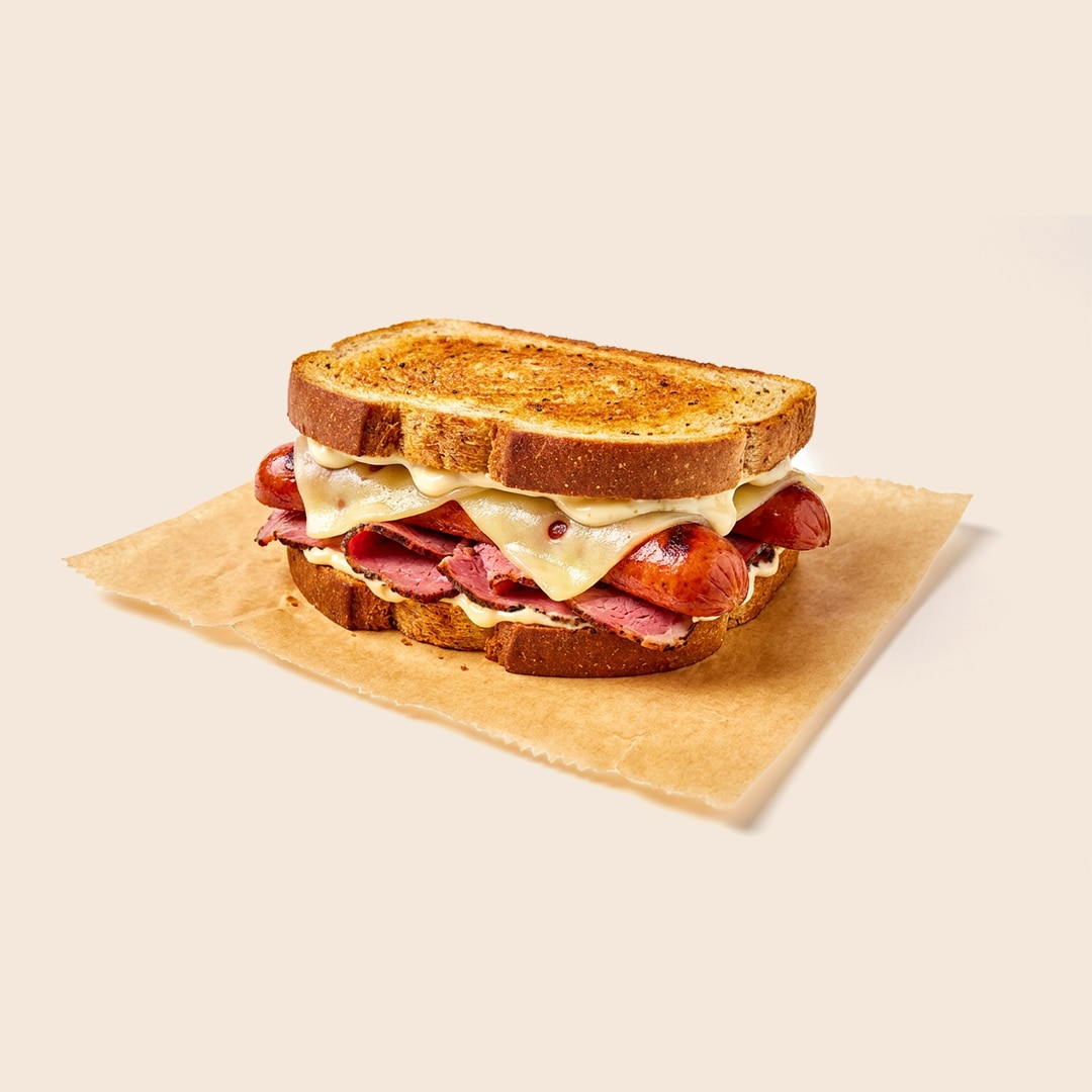Virginia sailor sandwich with pastrami, grilled knockwurst, melted Swiss cheese and mayo on toasted rye bread.