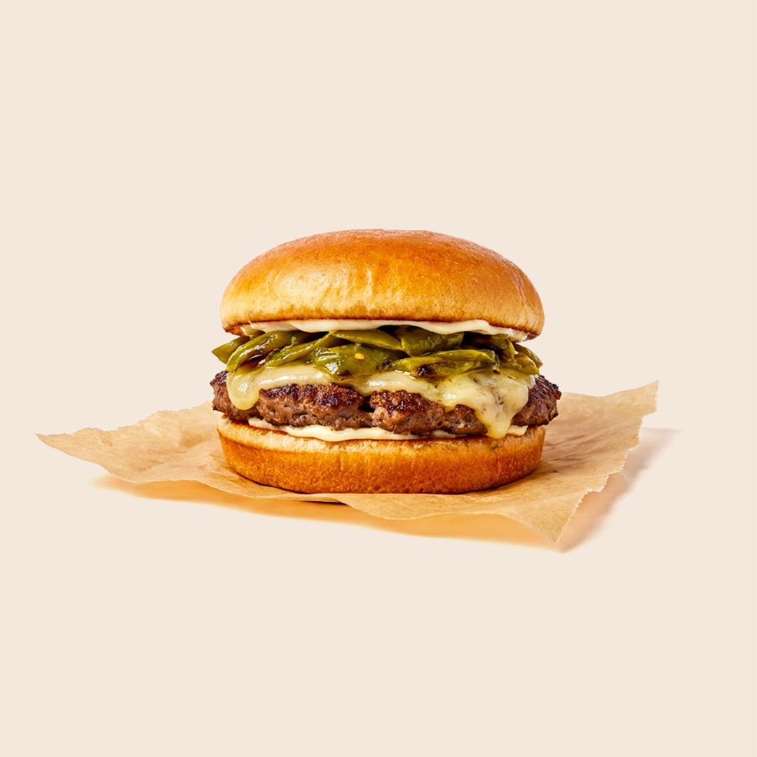 Green chile cheeseburger with a beef patty, melted cheese, roasted green chiles and mayo on a bun.
