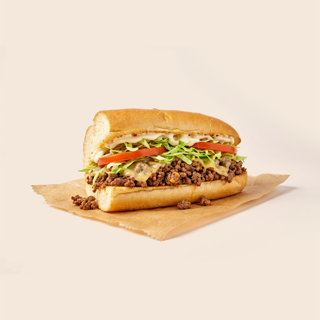 New York style chopped cheese sandwich with ground beef, melted cheese, lettuce, tomato and mayo on a hero roll.