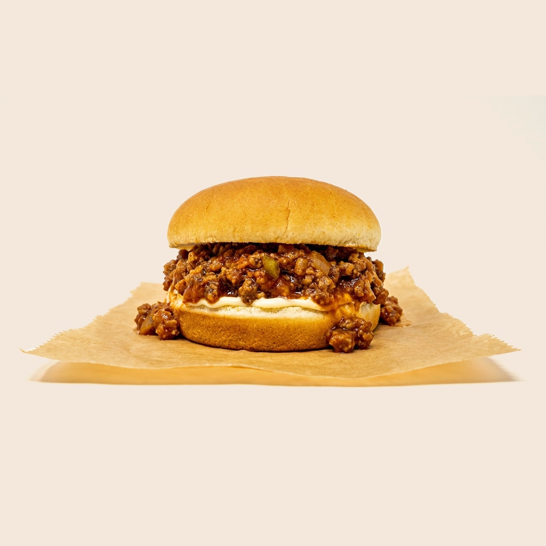 Sloppy Joe sandwich with seasoned ground beef, peppers and onions, and mayo on a bun.