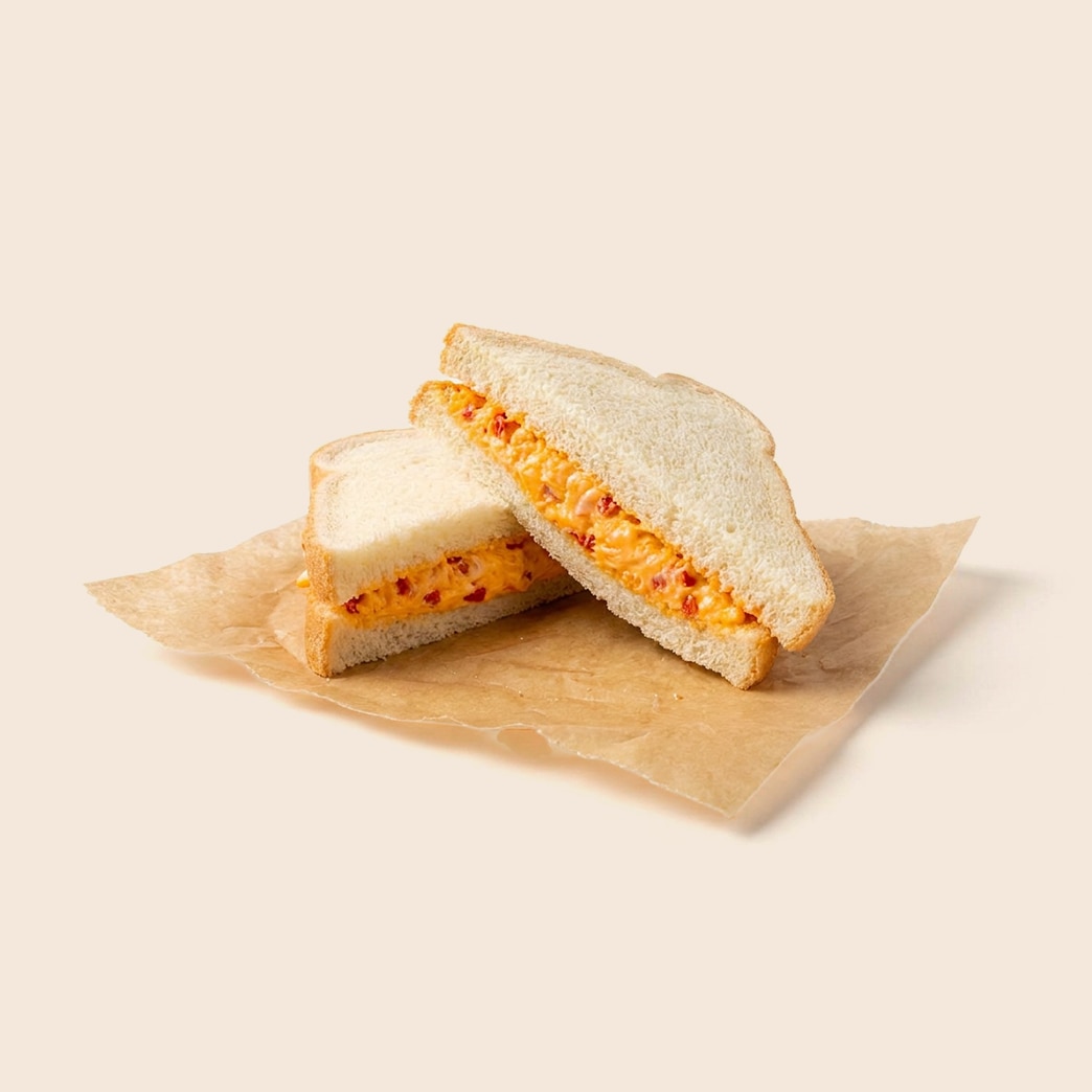 Classic pimento cheese sandwich on white bread, cut in half. 