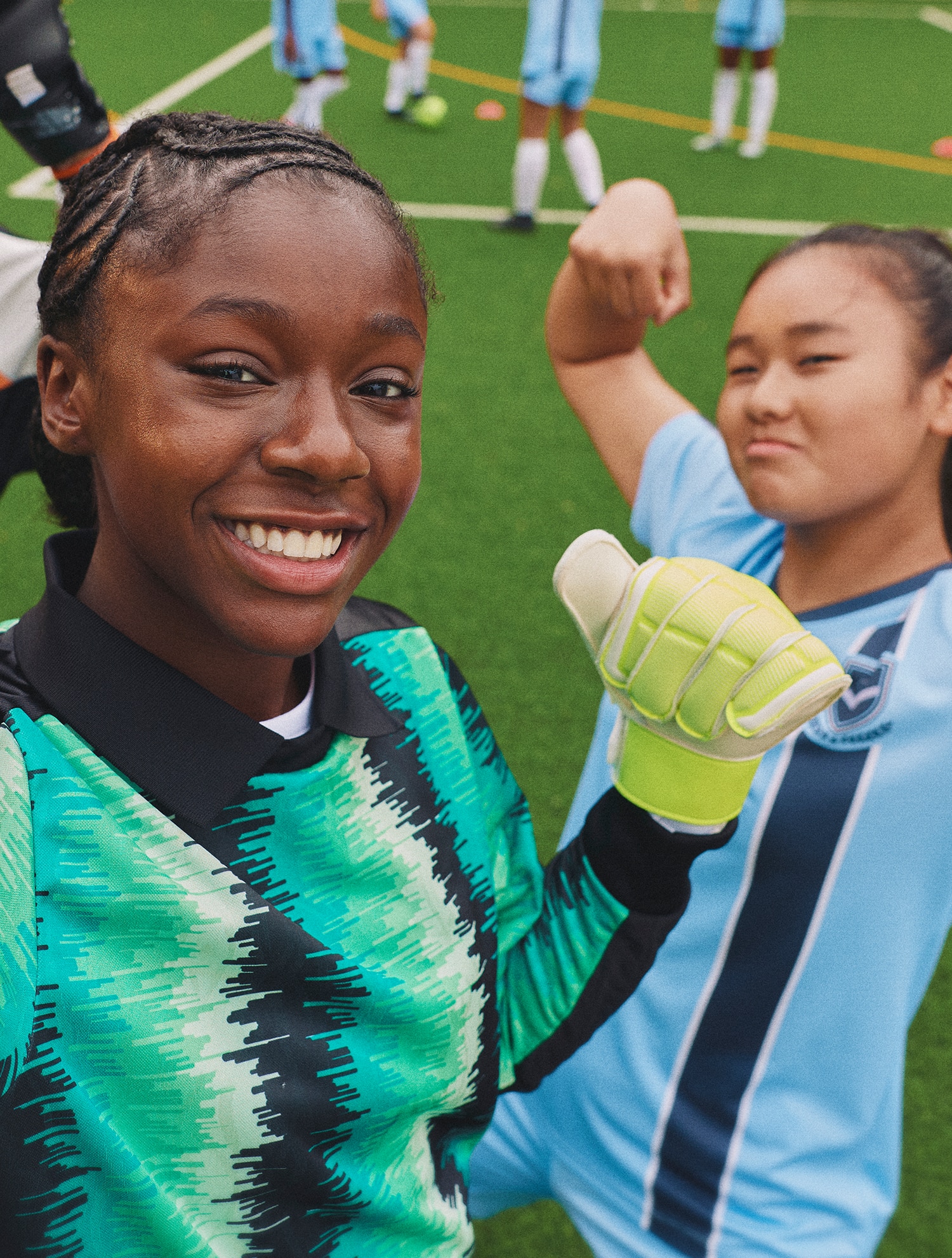 Two girls smiling of football pitch 