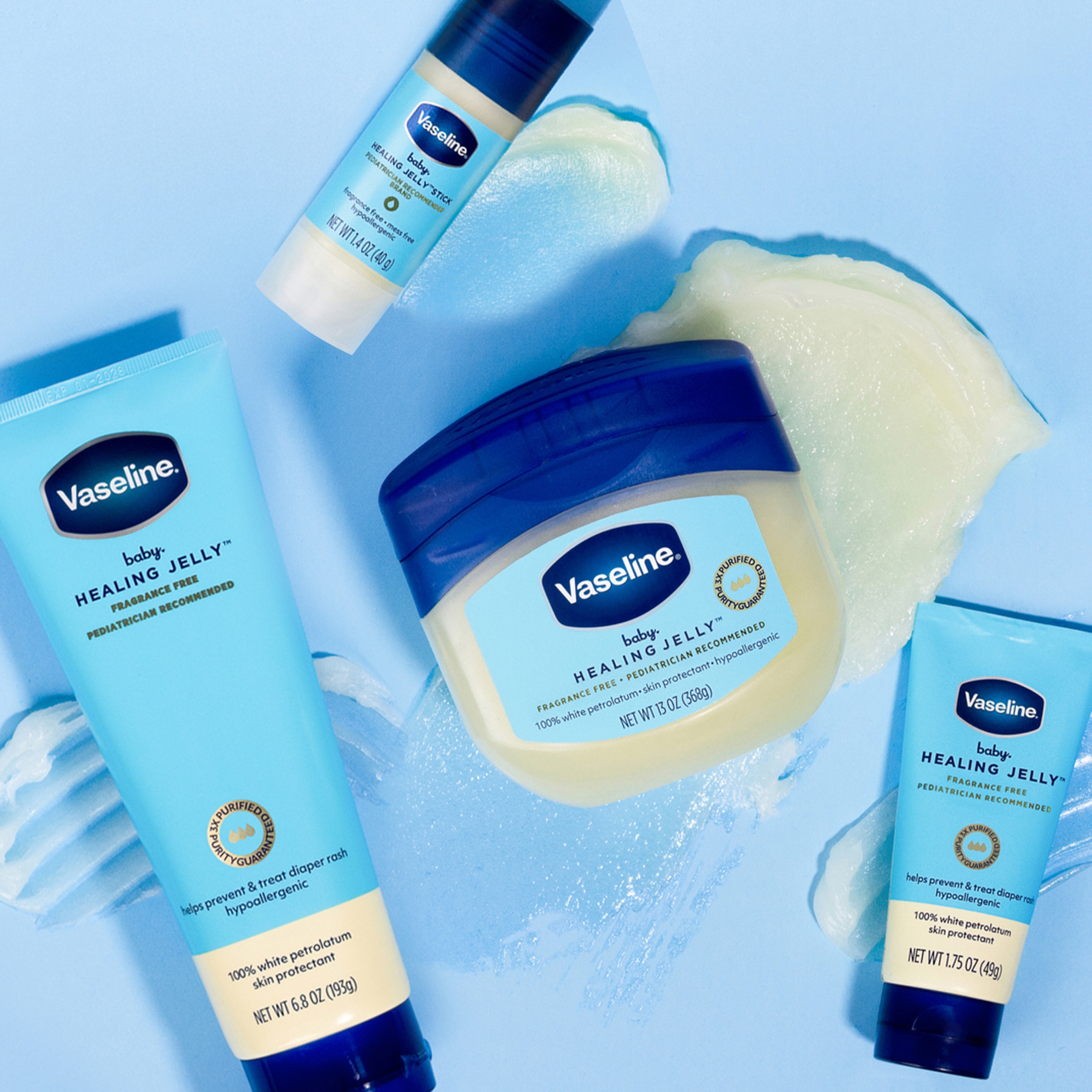 Several Vaseline Baby Healing Jelly products, including a jar, tubes, and a stick, are displayed on a blue background with swirls of jelly.