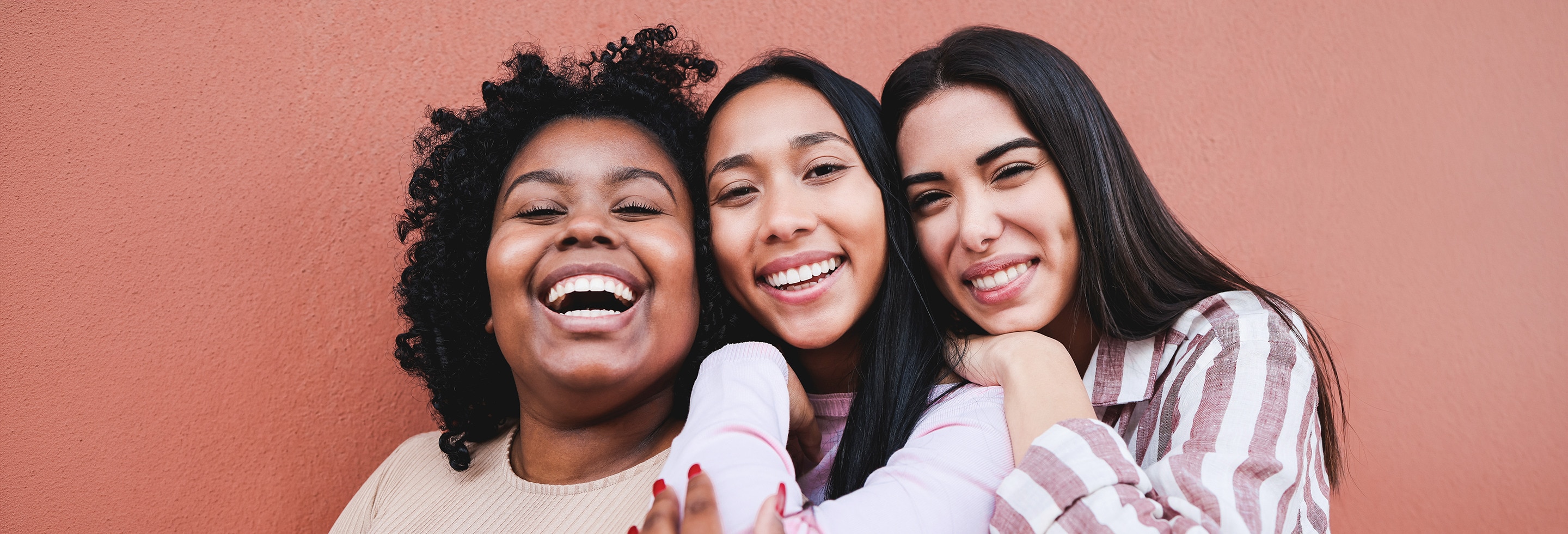 Three women hugging each other and smiling