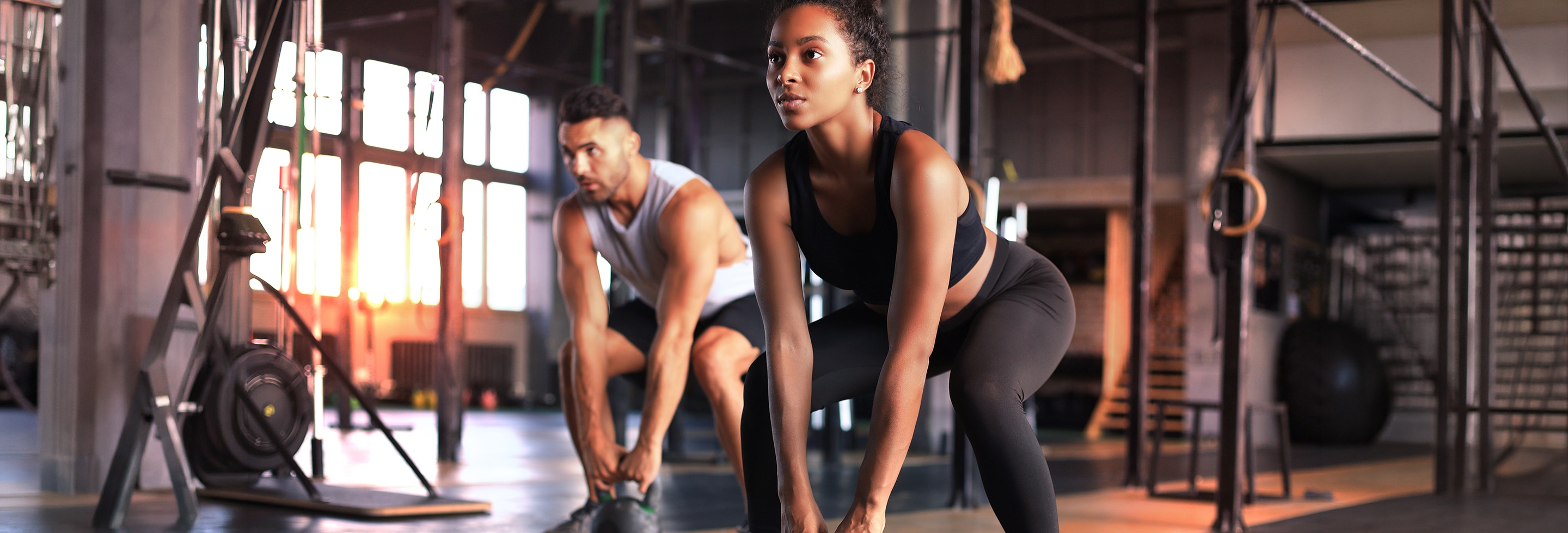 Person joyfully stretching on a bed in a bright, cozy bedroom knowing the benefits of morning exercise. 