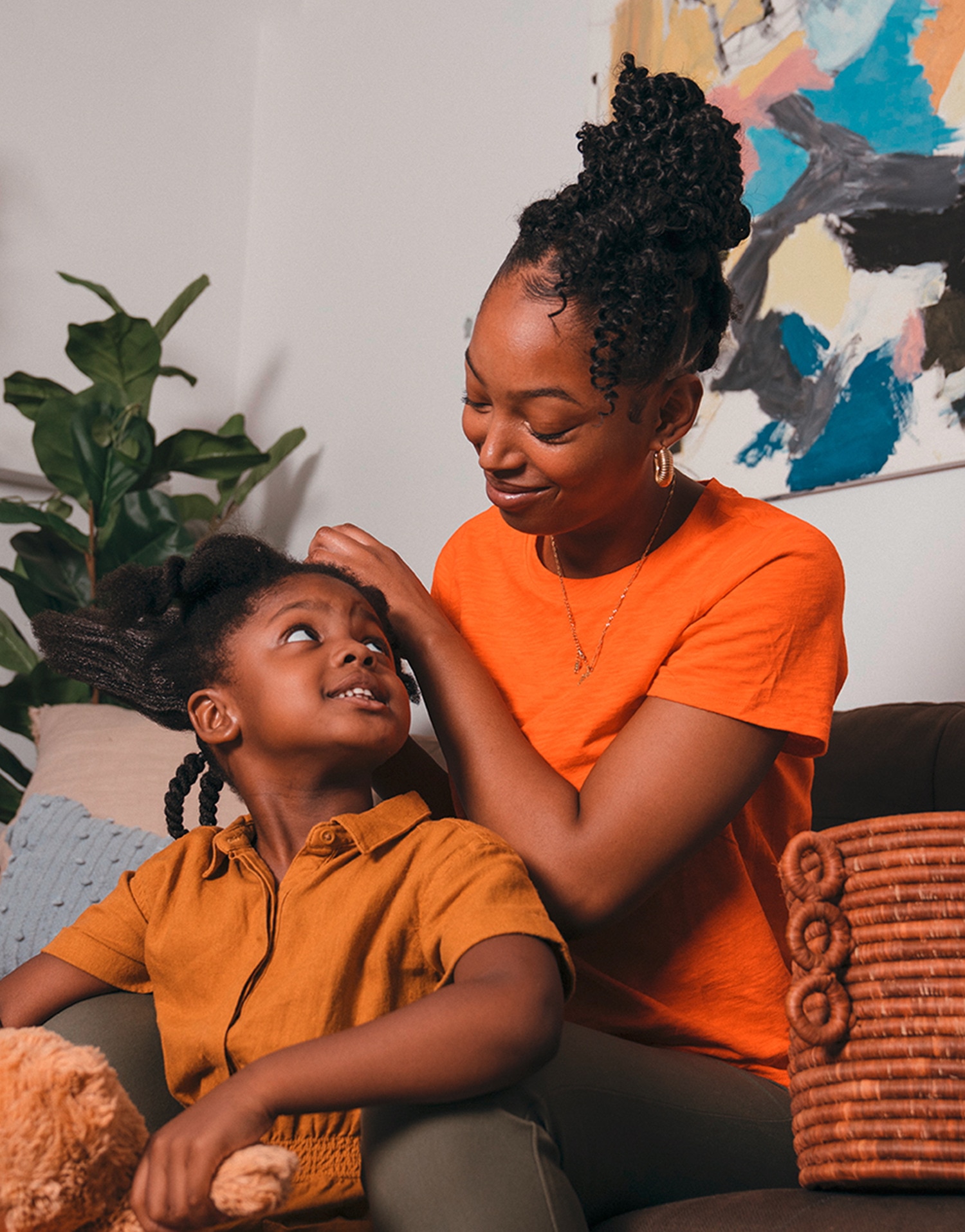 A mother doing her daughter's hair