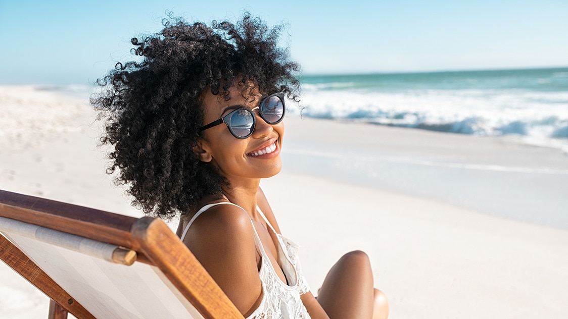 Young African American woman smiling and using a skin care product