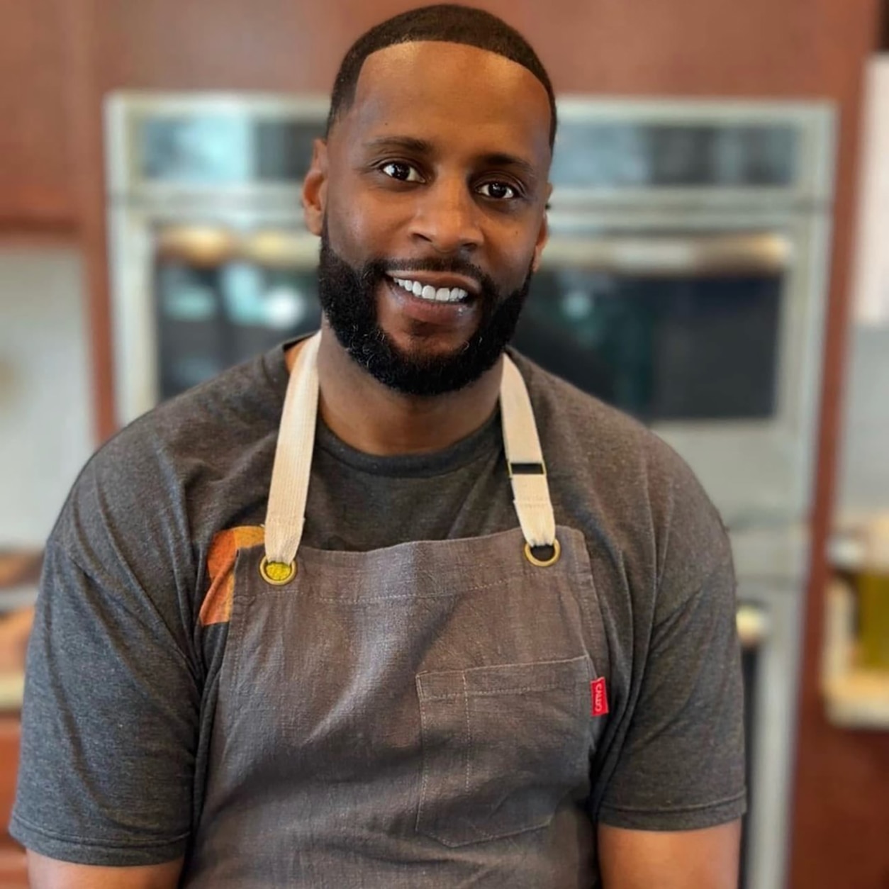 Portrait of a person wearing an apron in a kitchen setting, suitable for cooking, culinary and lifestyle-related content.
