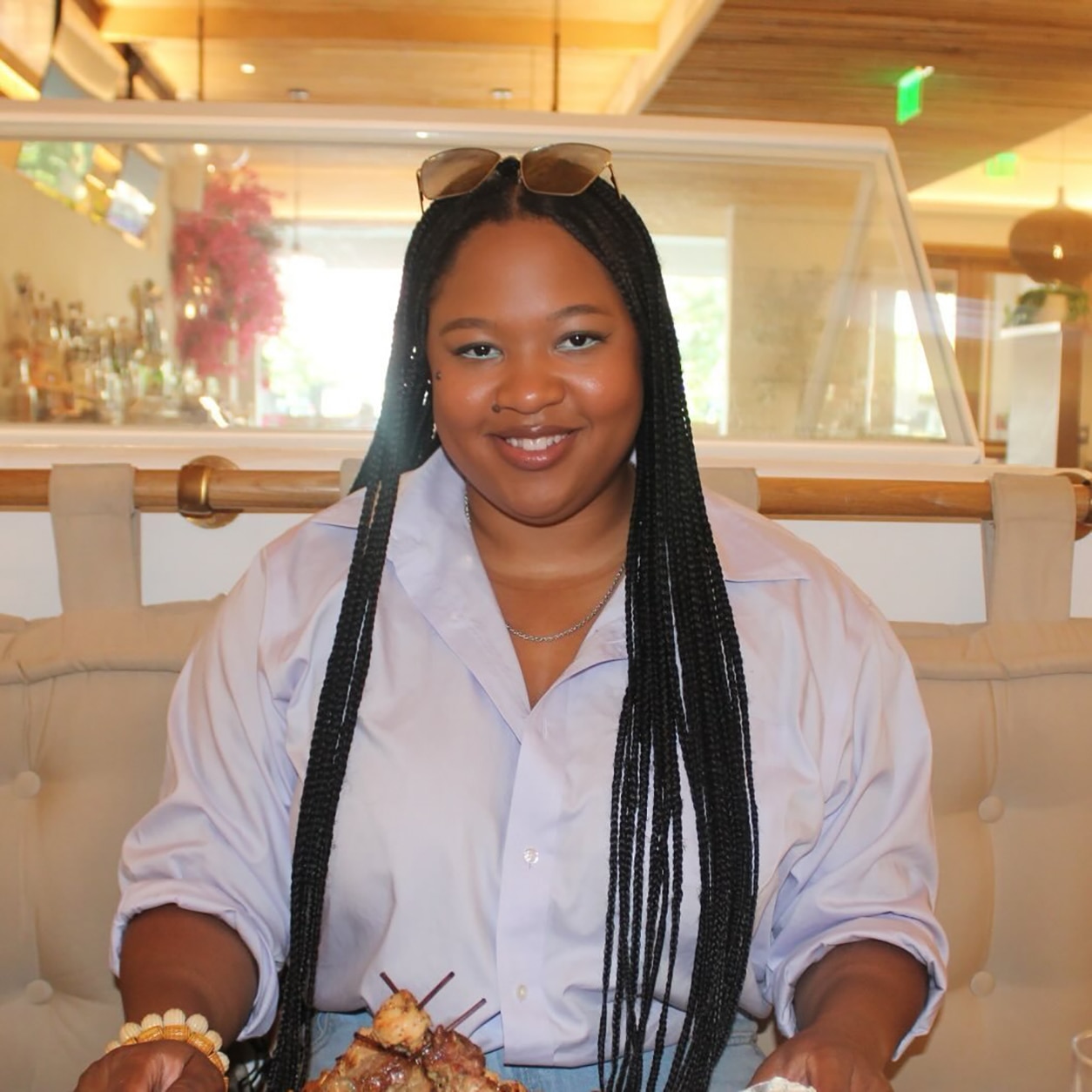 women with long braided hair smiling