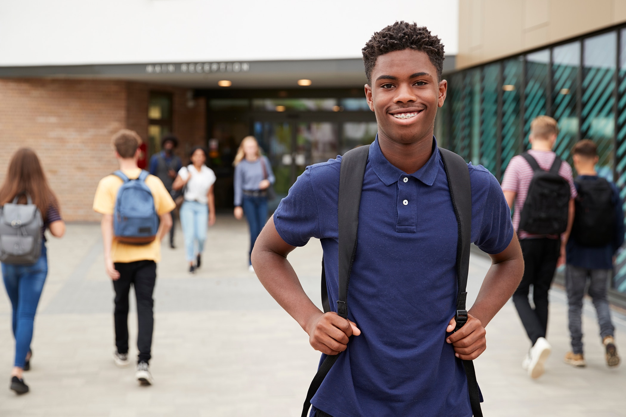 High school student smiling because he’s comfortable and confident wearing the best deodorant for teen boys