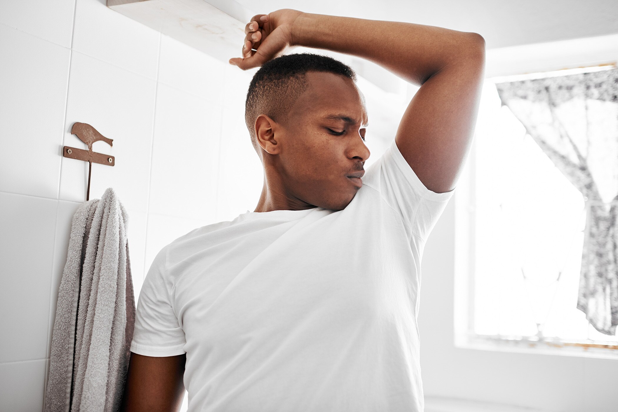 Man smelling body odor without sweating and no visible sign of sweat