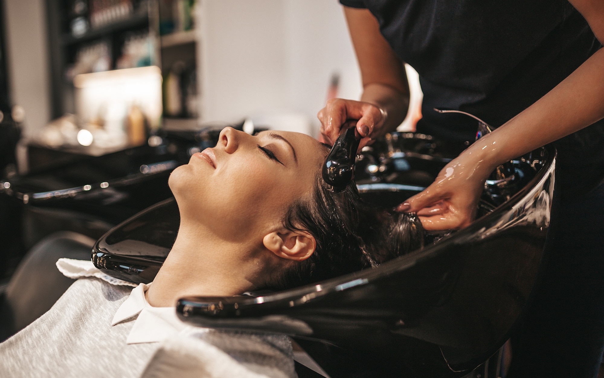 Woman relaxing in a salon having her hair washed.