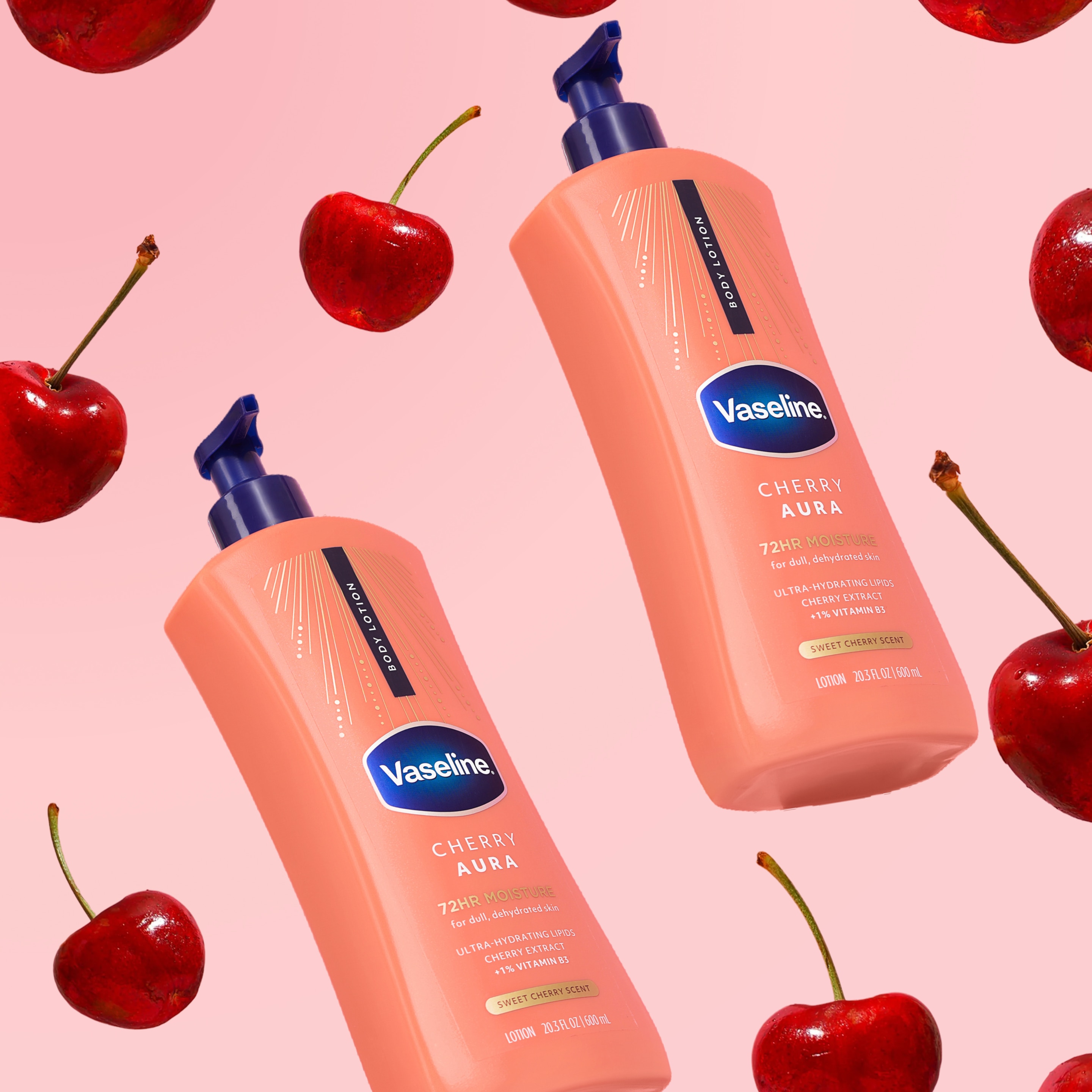 Two bottles of Vaseline Cherry Aura body lotion are surrounded by bright red cherries