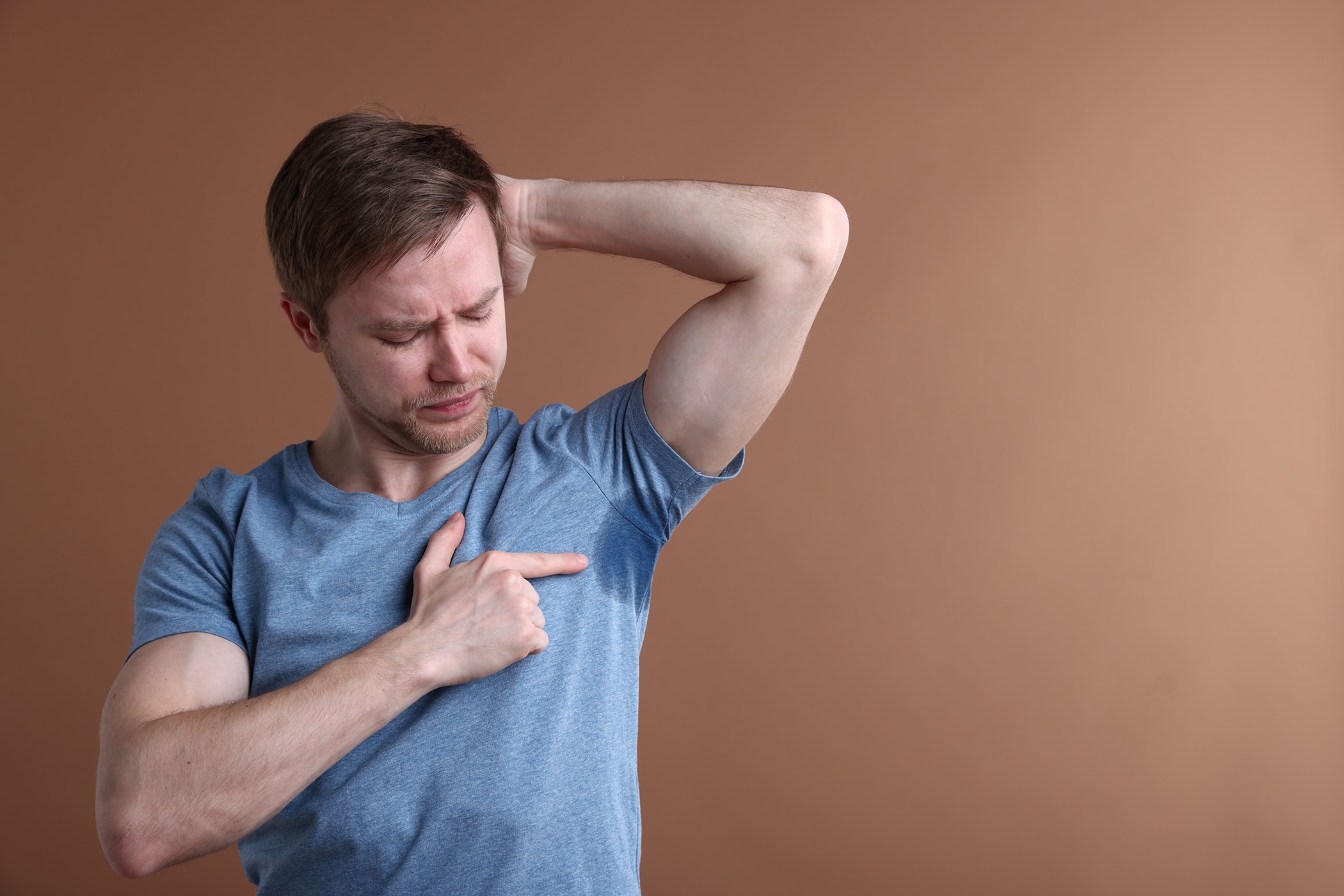 Young guy experiencing stress sweat and discomfort at summer’s end