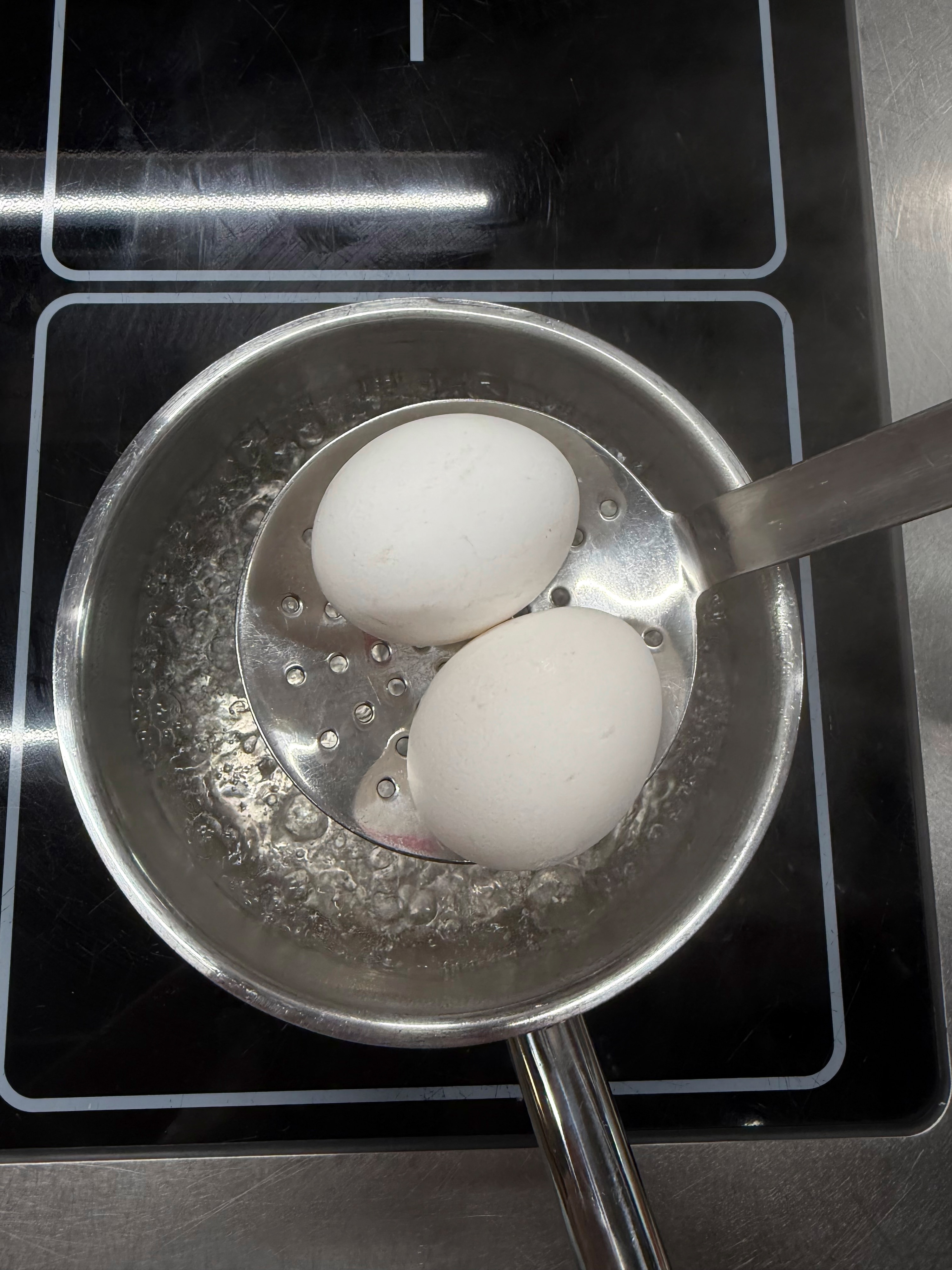 Eier kochen step by step: 2. Eier mit dem Schaumlöffel ins Wasser geben