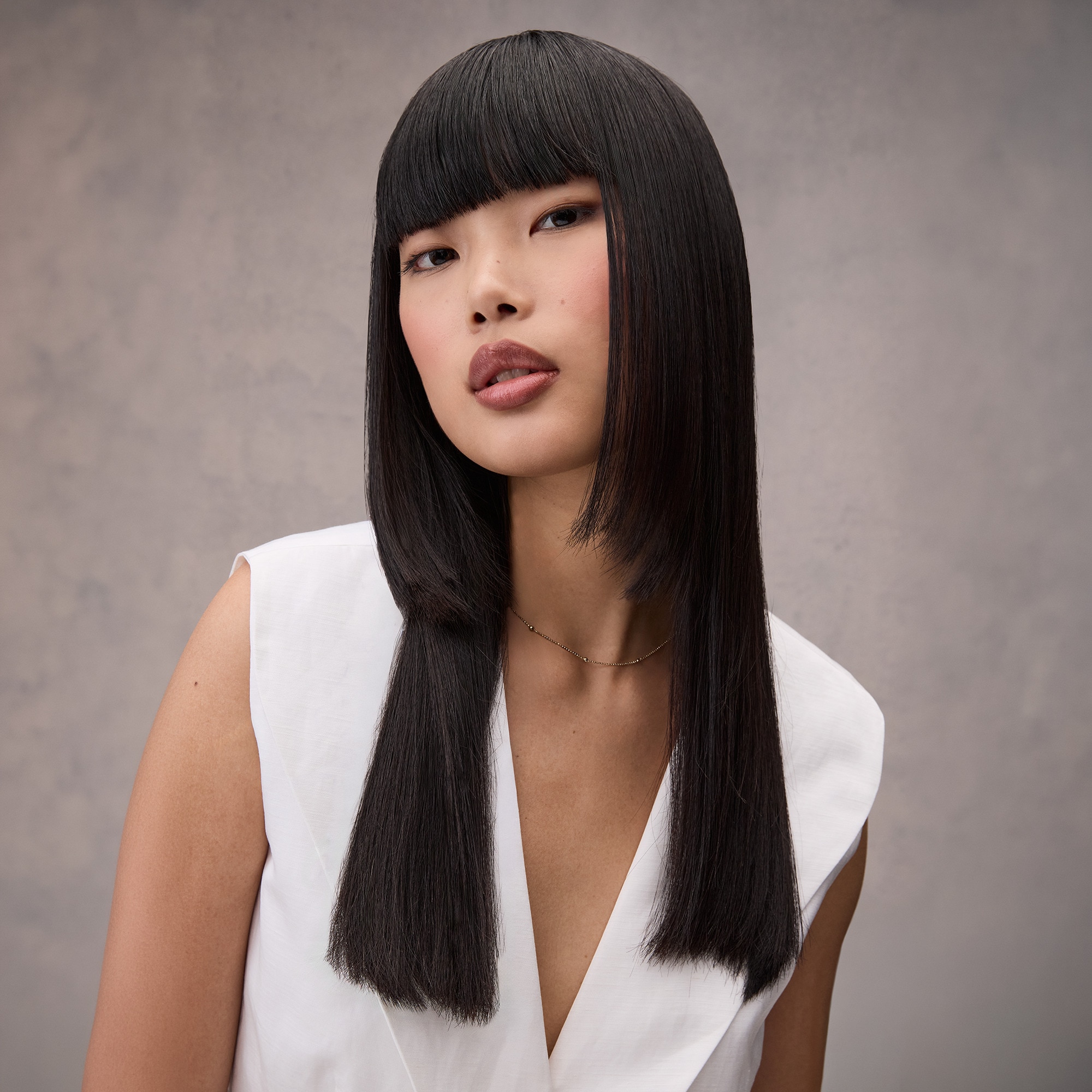 Woman with dark brown hair in a sleek jellyfish haircut