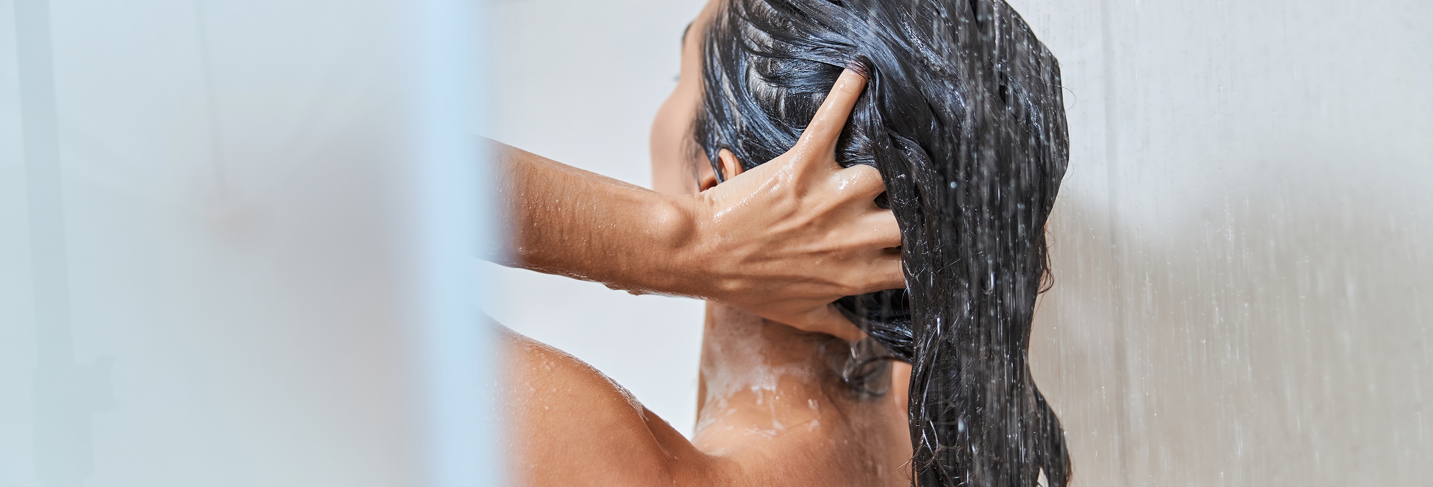 Woman using the best conditioner for dry hair in the shower