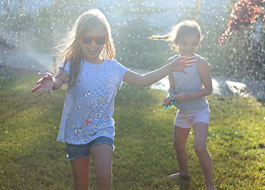 Outdoor play in a sprinkler on a sunny day