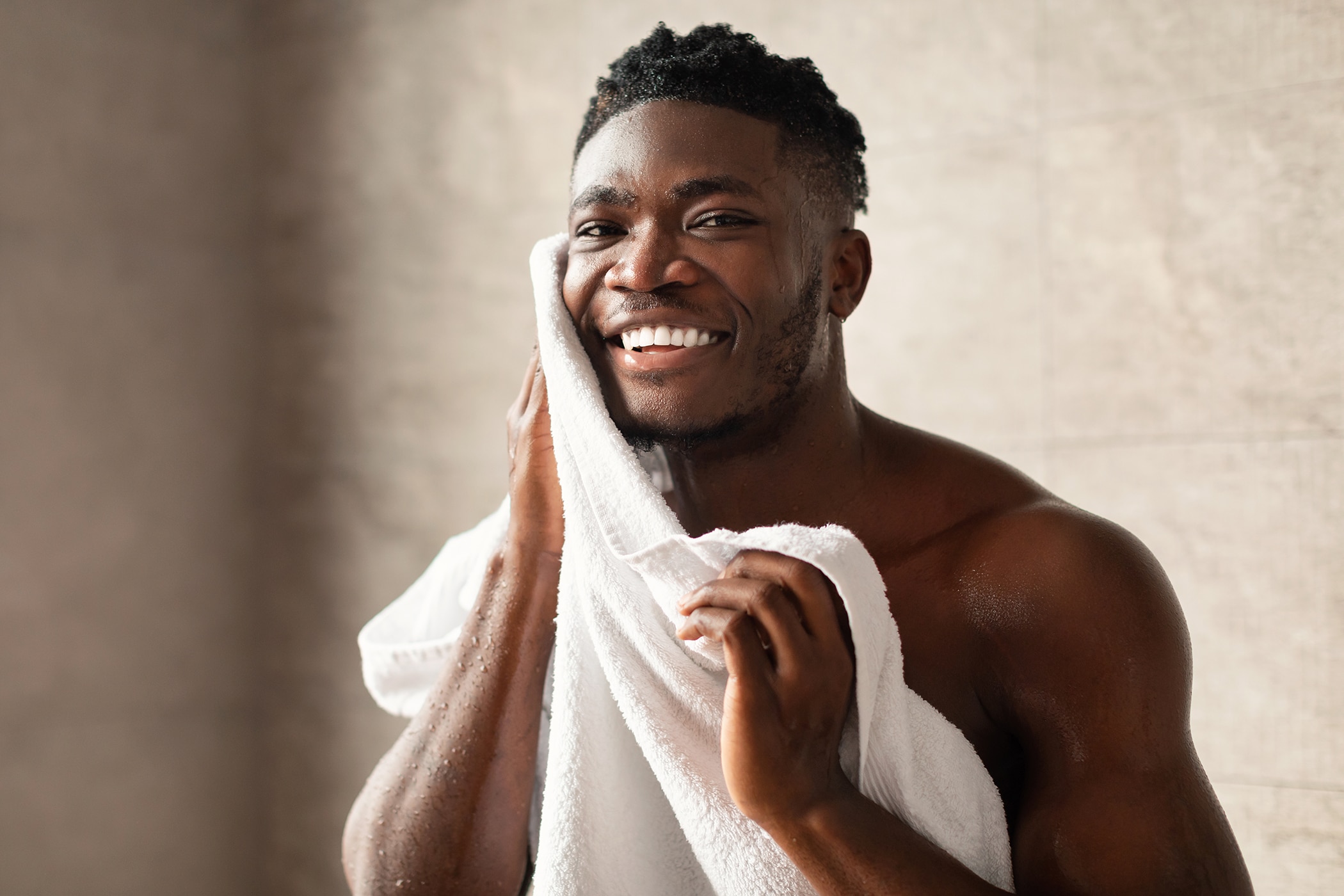 Afro American man drying off with a towel after using moisturizing body wash