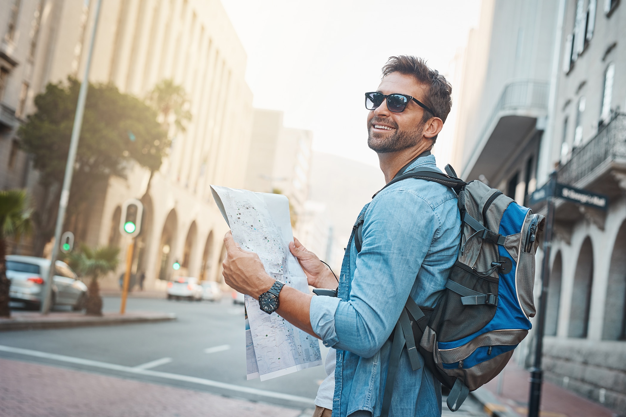 Man holding a map smiling because he knows how to smell good all day