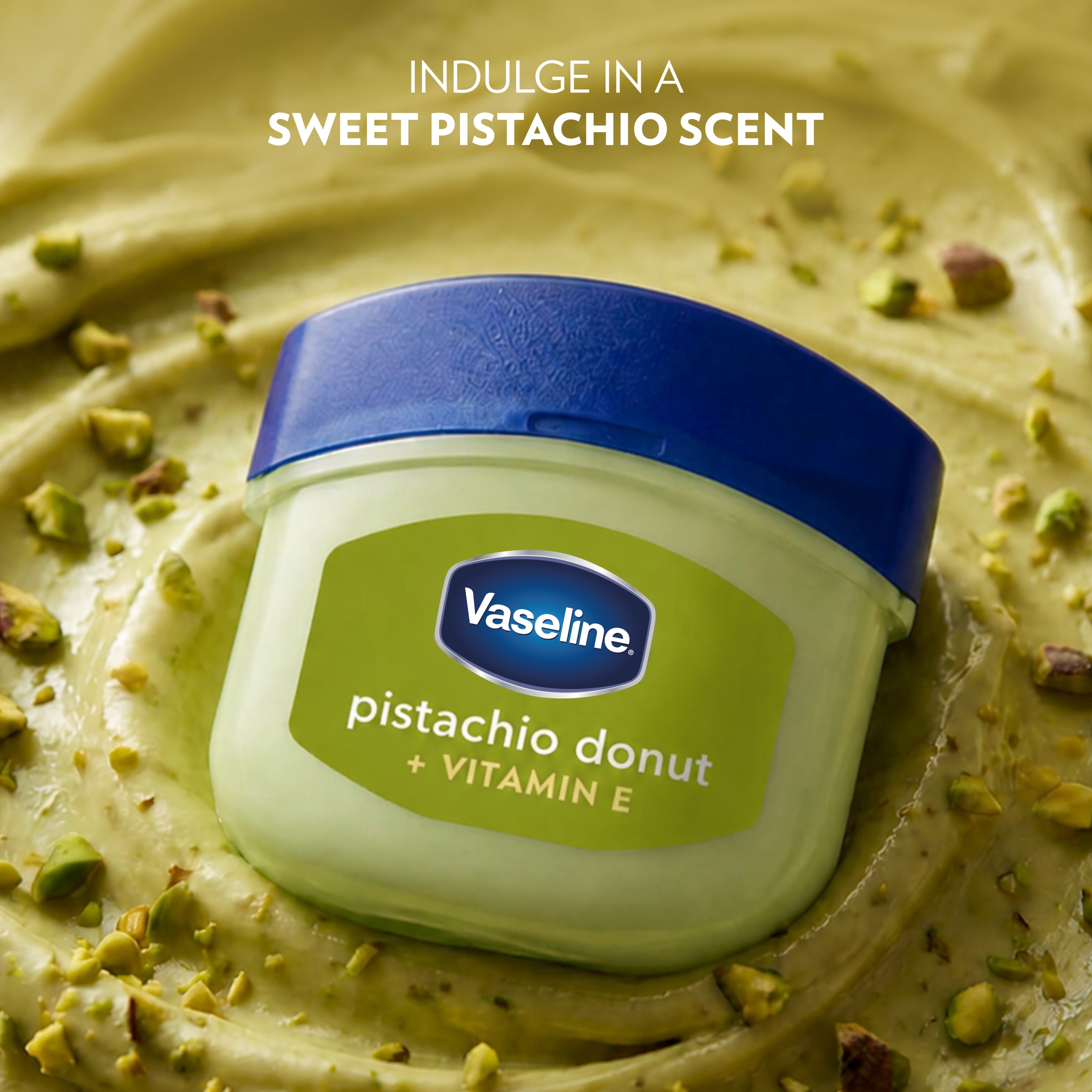 Container of Vaseline Lip Therapy Jelly Pistachio Donut + Vitamin E displayed on a creamy pistachio-textured background with chopped pistachios, alongside text