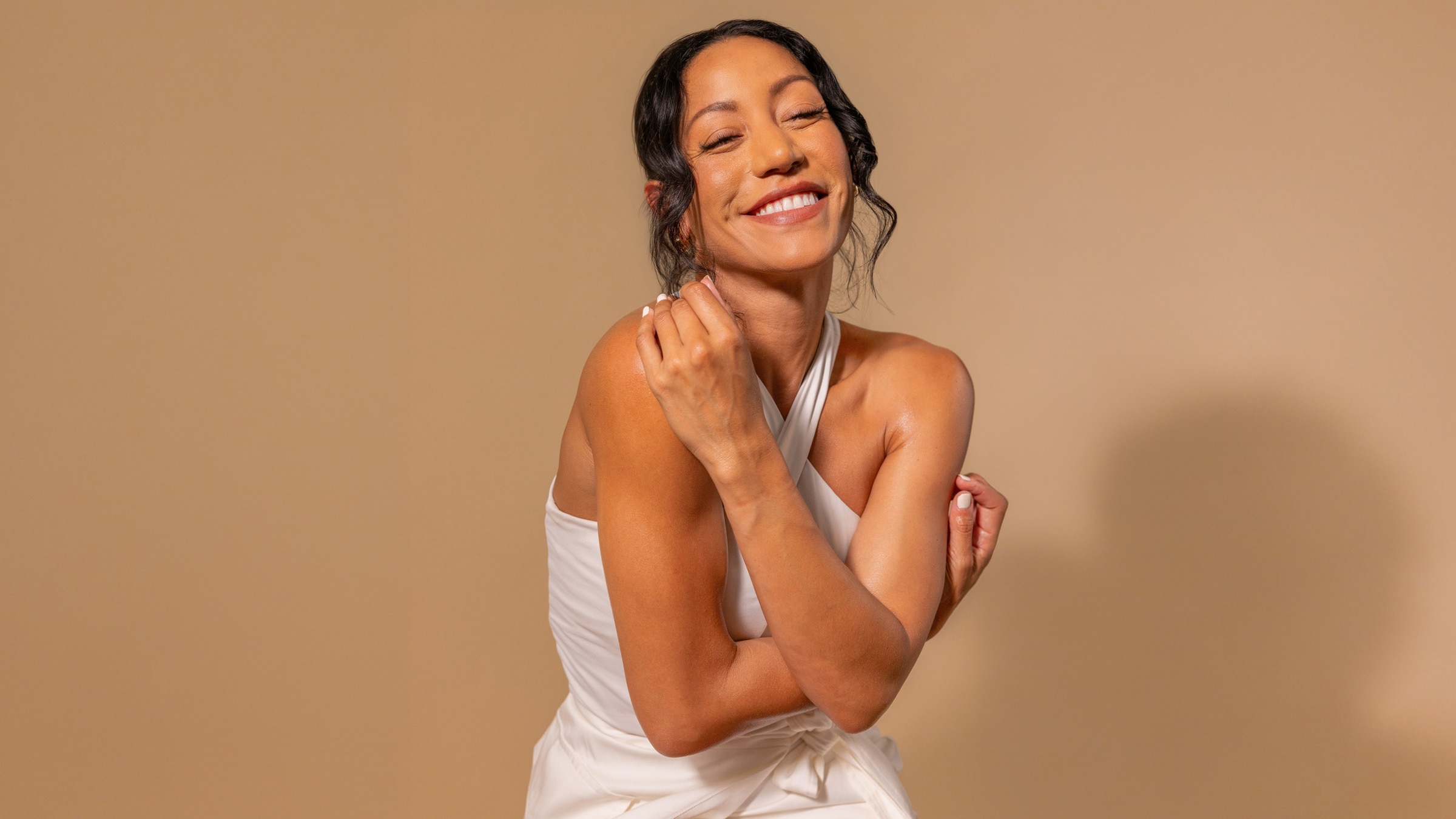 Smiling woman in white top with radiant, hydrated skin