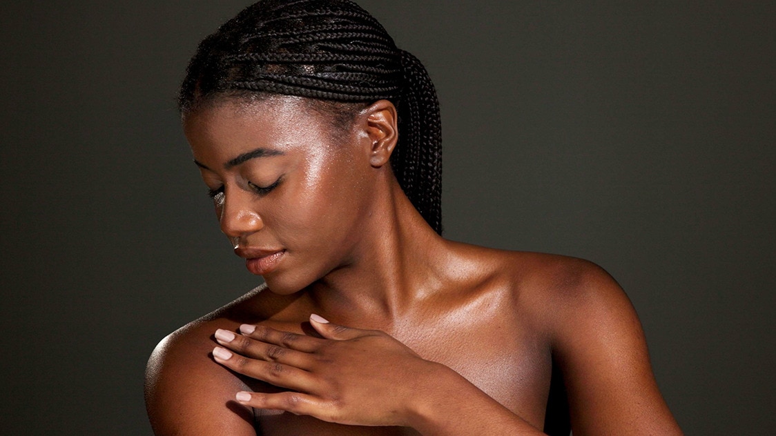 Woman feeling her soft skin after exfoliating during her skin cycling routine